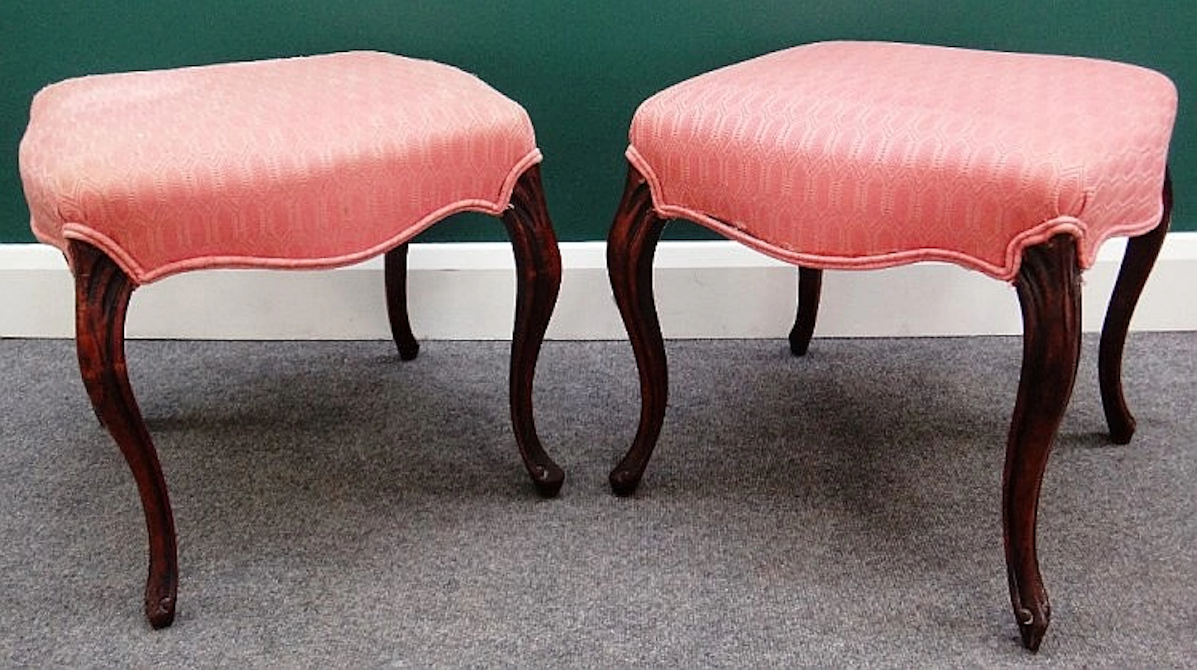 A pair of Victorian mahogany framed footstools of serpentine outline, on ca