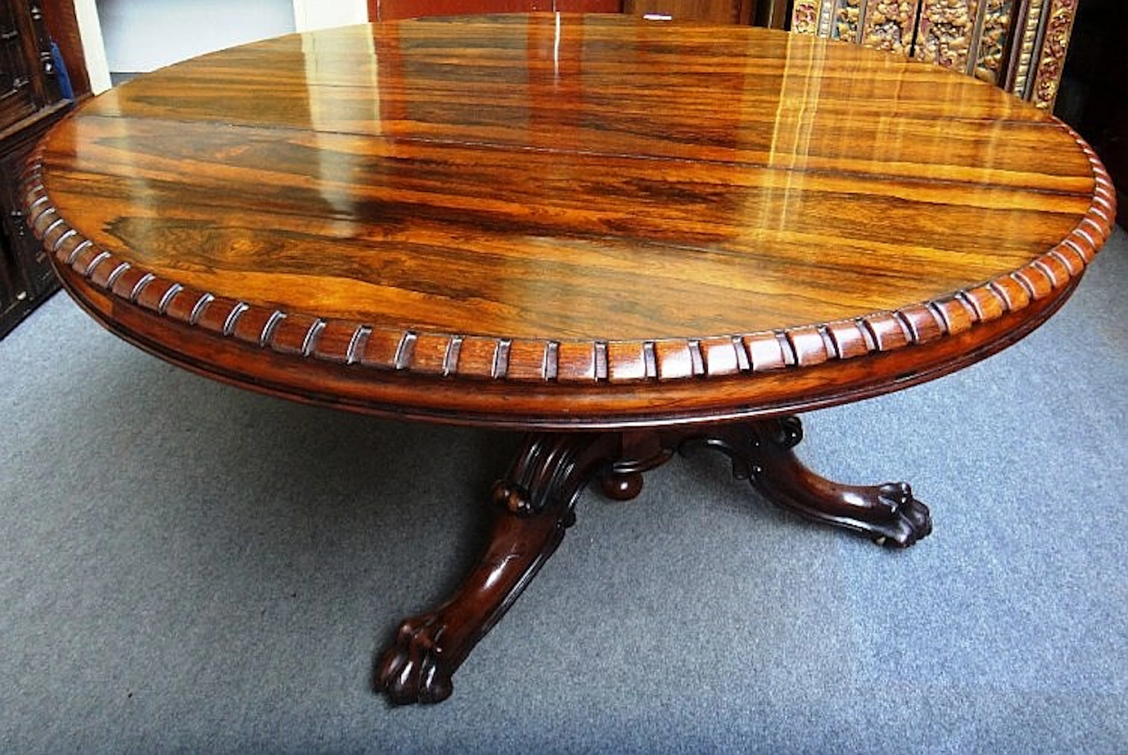 A Victorian rosewood dining table, the circular dentil moulded snap top on