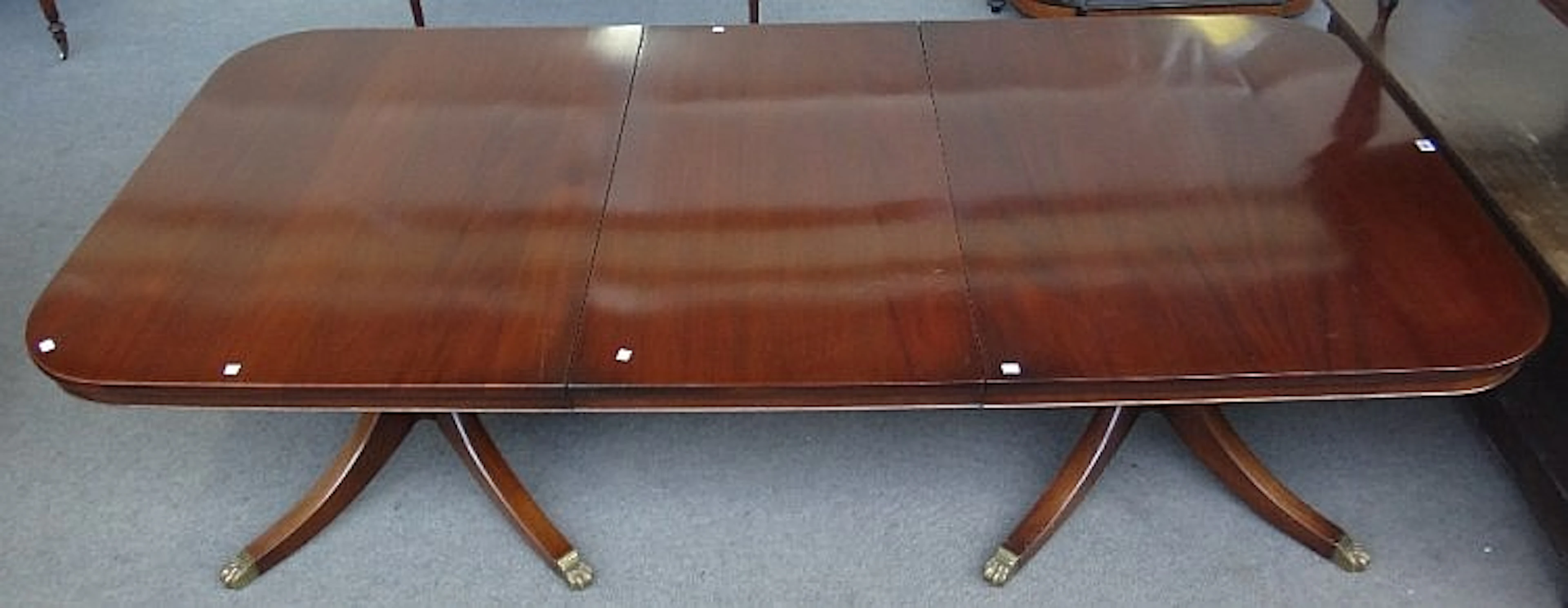 A Regency style mahogany twin pillar extending dining table, on eight downs