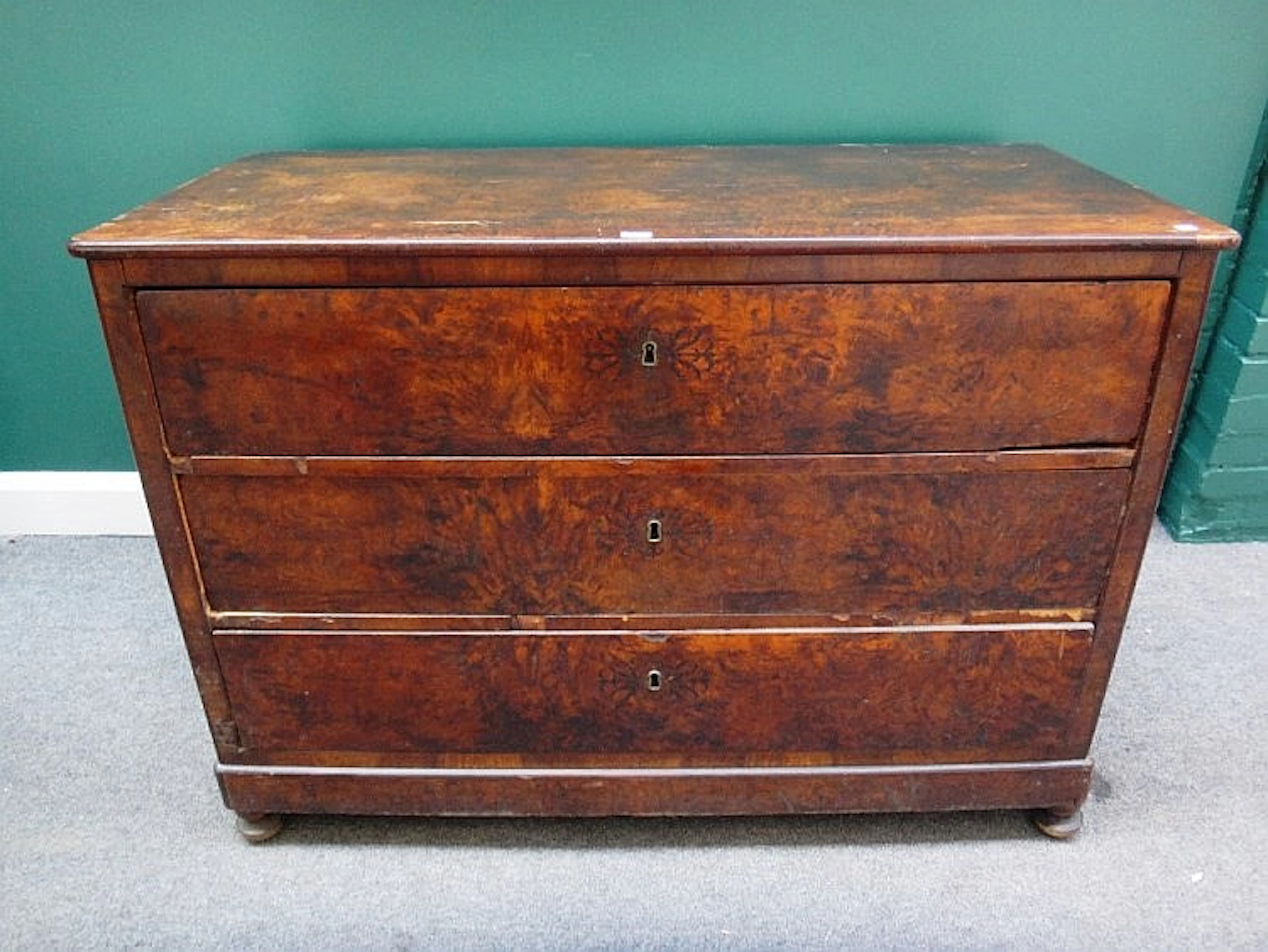A 19th century French figured walnut commode of three long drawers on bun f