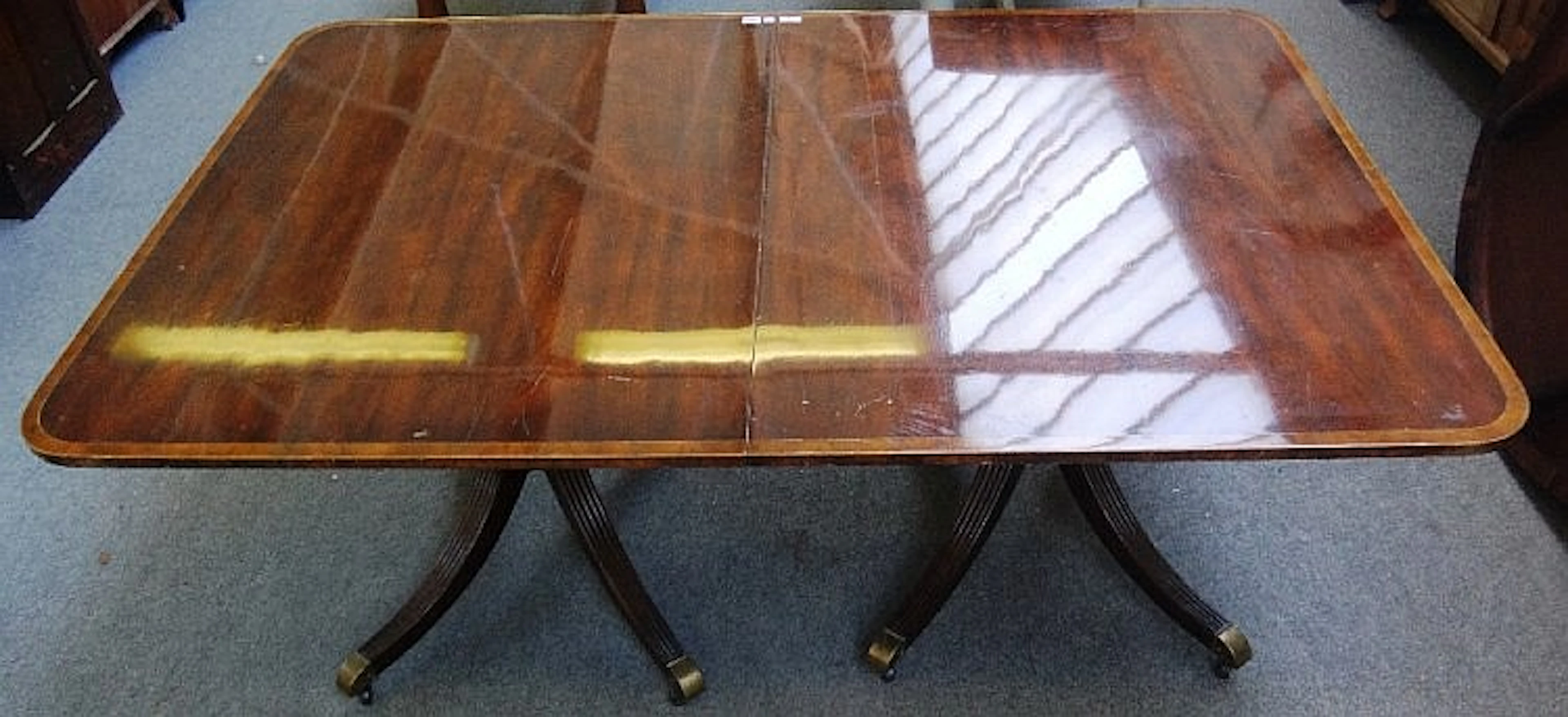 A Regency style mahogany 'D' end extending dining table, the crossbanded to
