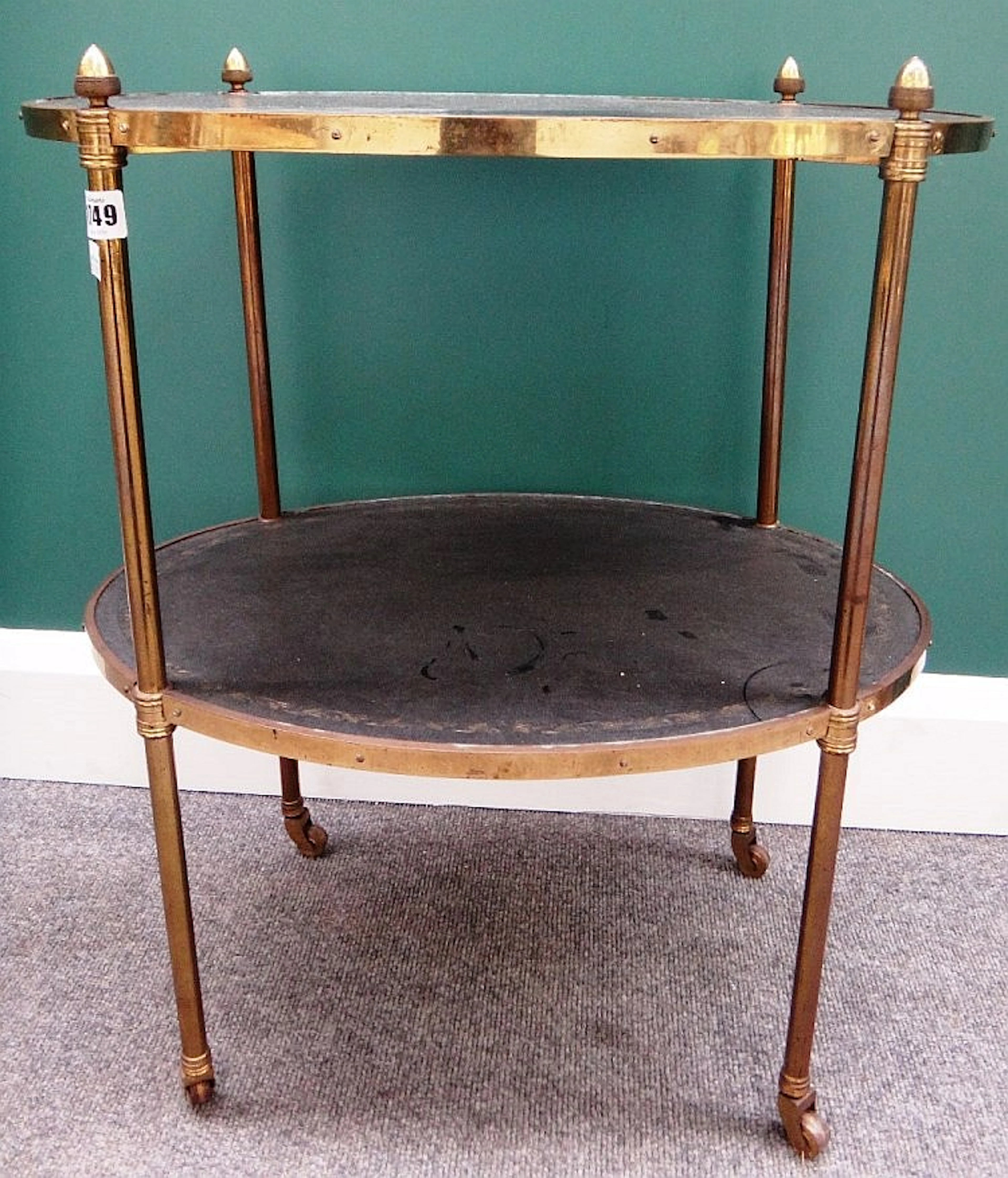A 19th century lacquered brass oval two tier étagère, with gilt tooled blac