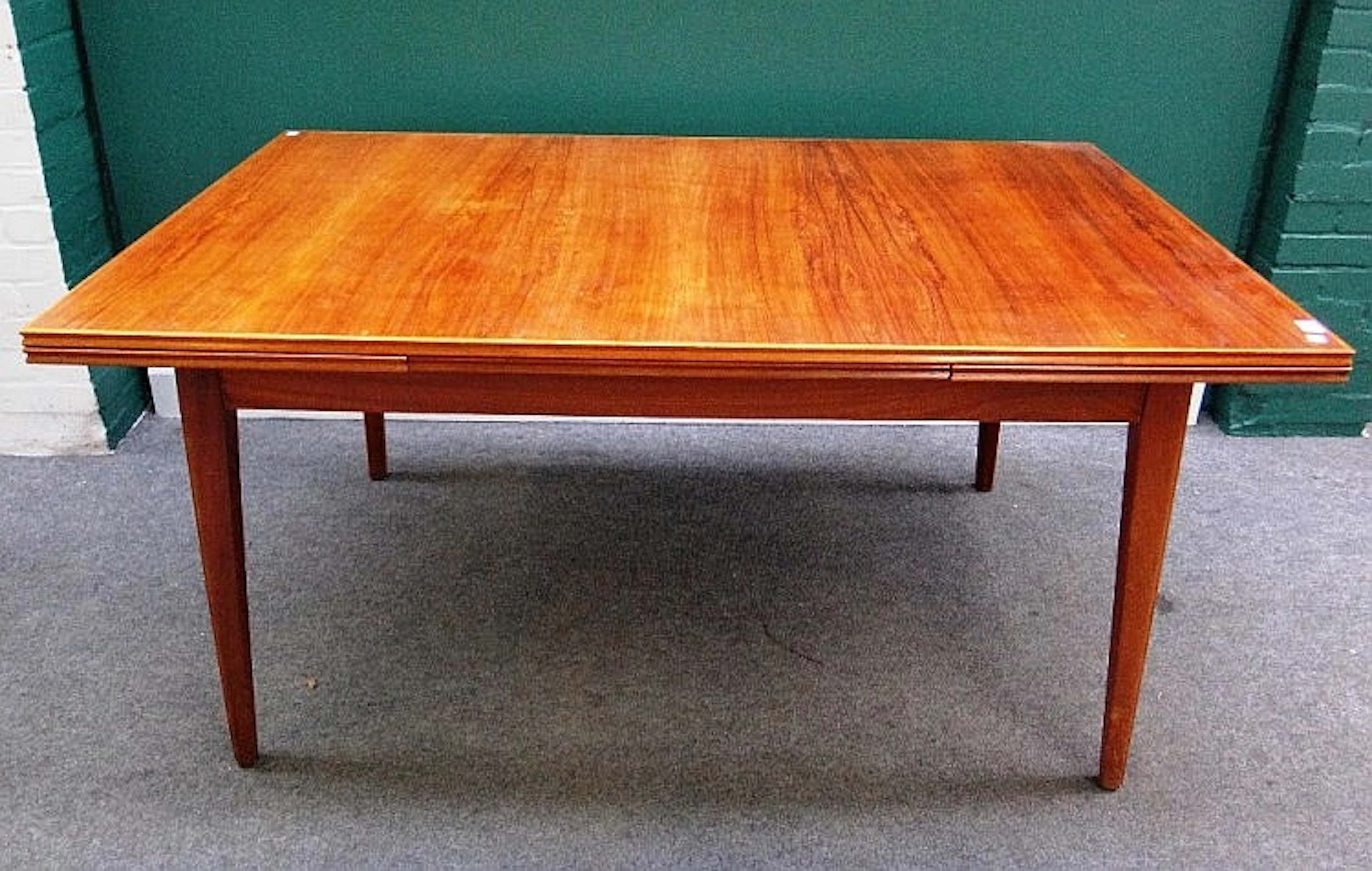 A mid-20th century teak rectangular extending dining table on tapering squa