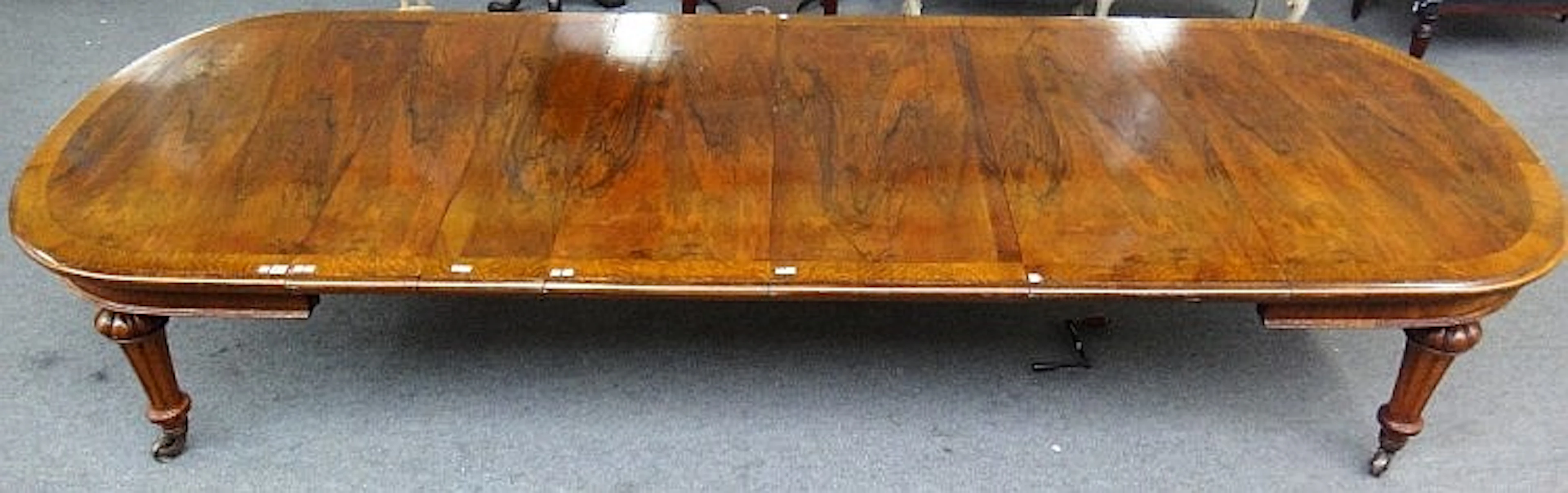 A Victorian oak banded walnut oval extending dining table, on tapering flut