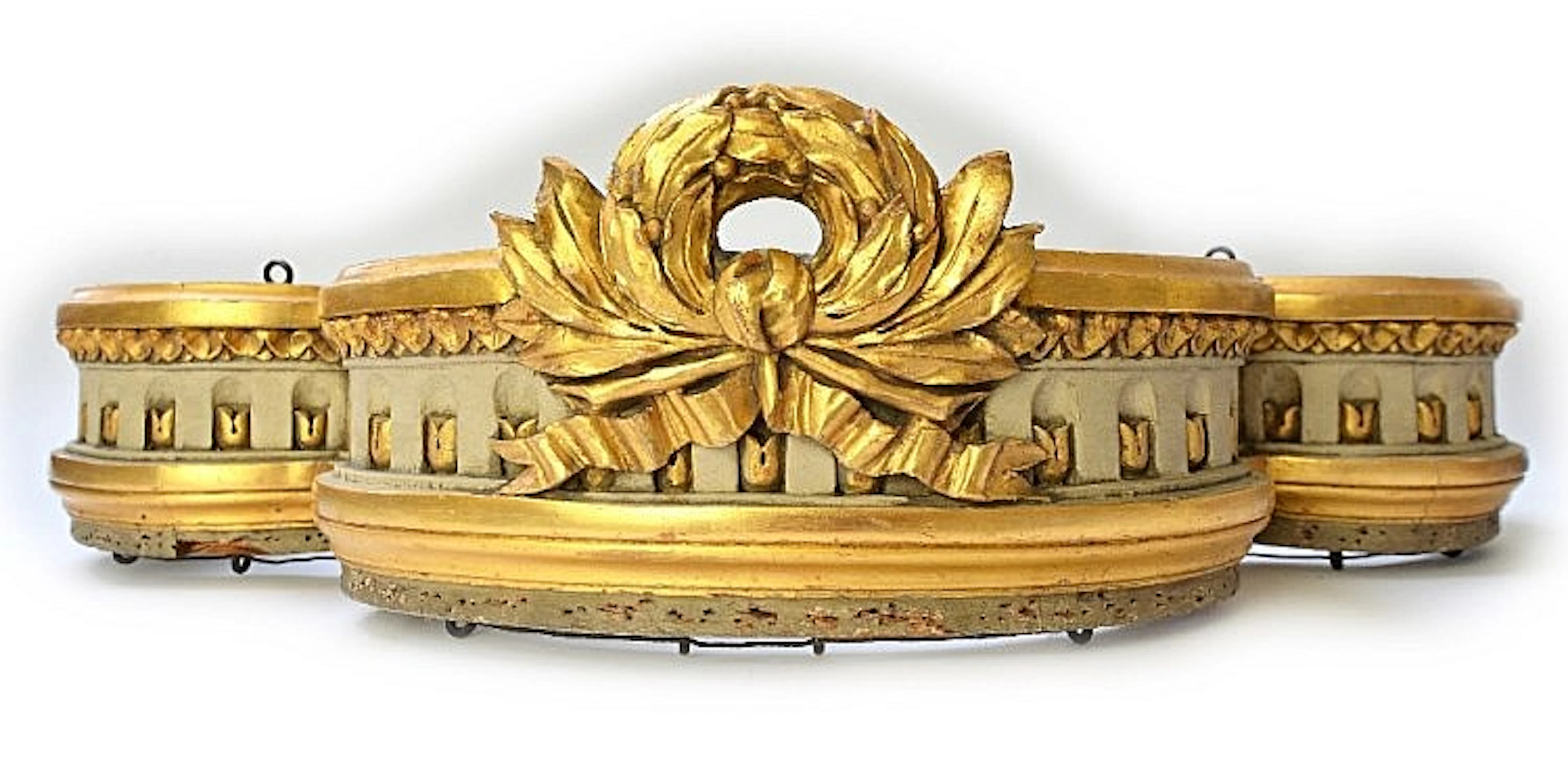 A late 19th/early 20th century cream and gilt pelmet, with ribbon tied wrea