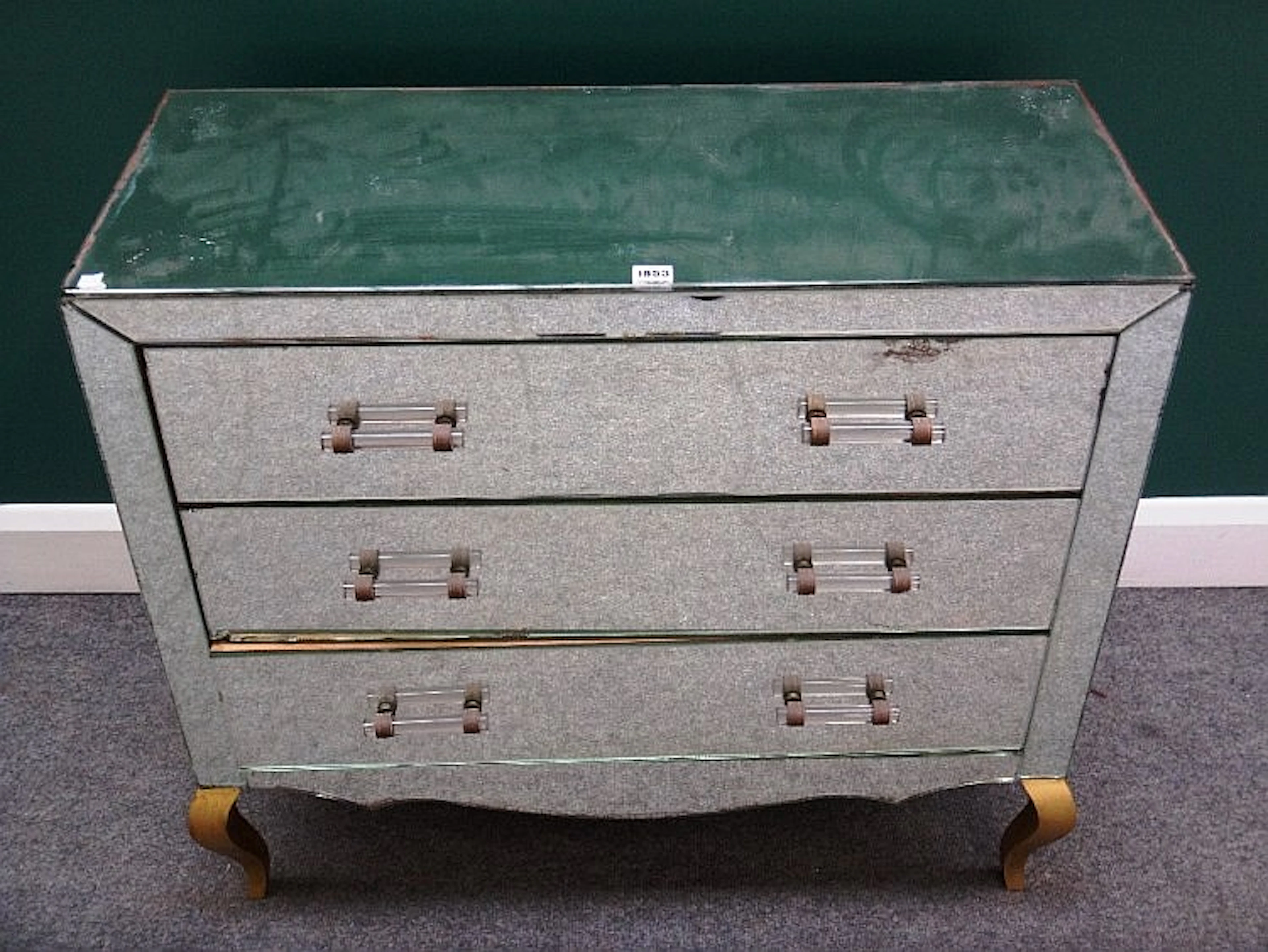 A 20th century mirror veneered chest of three long drawers on gilt cabriole