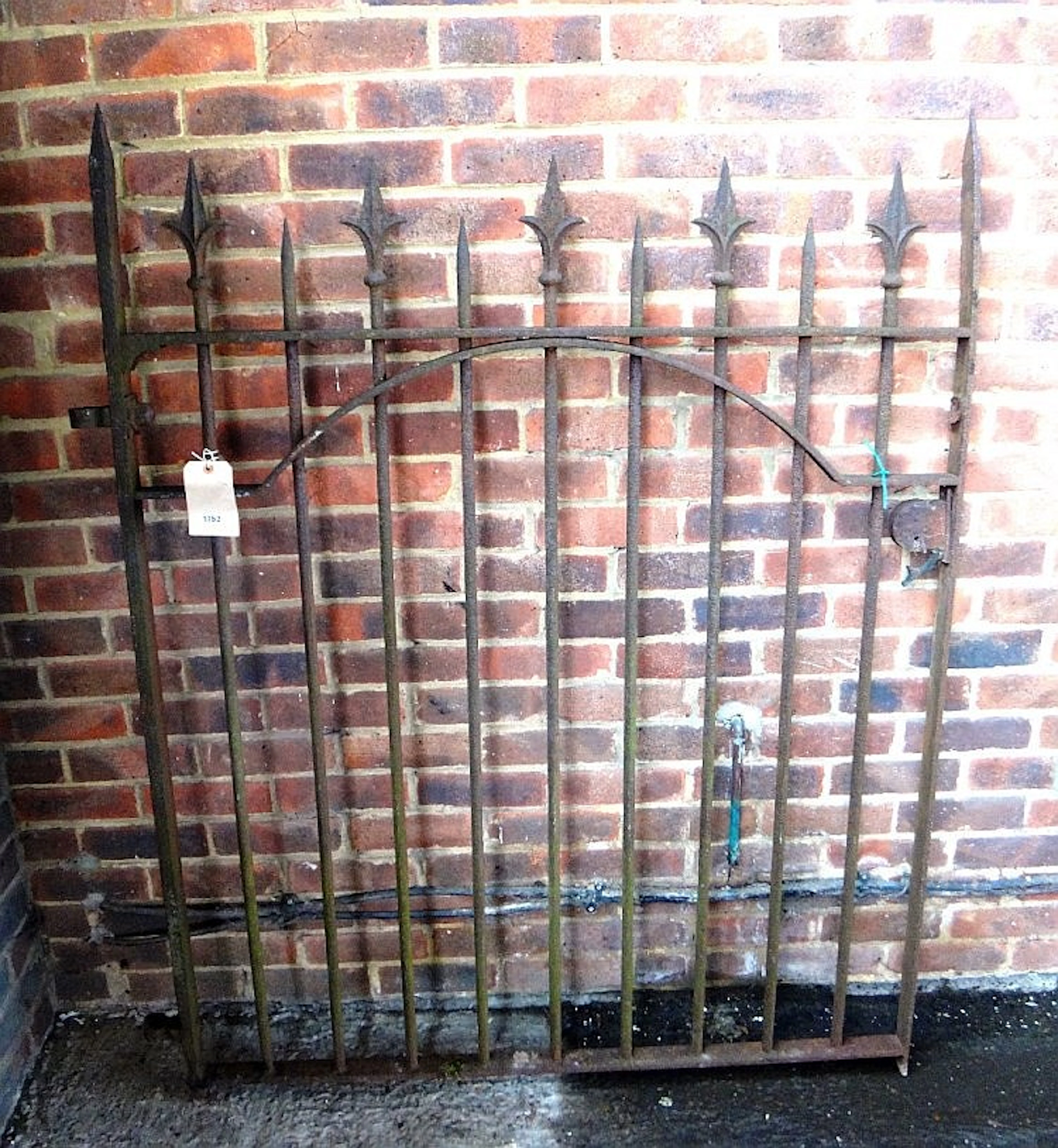 A mid-Victorian wrought iron gate with fleur de lys finials, 124cm wide and