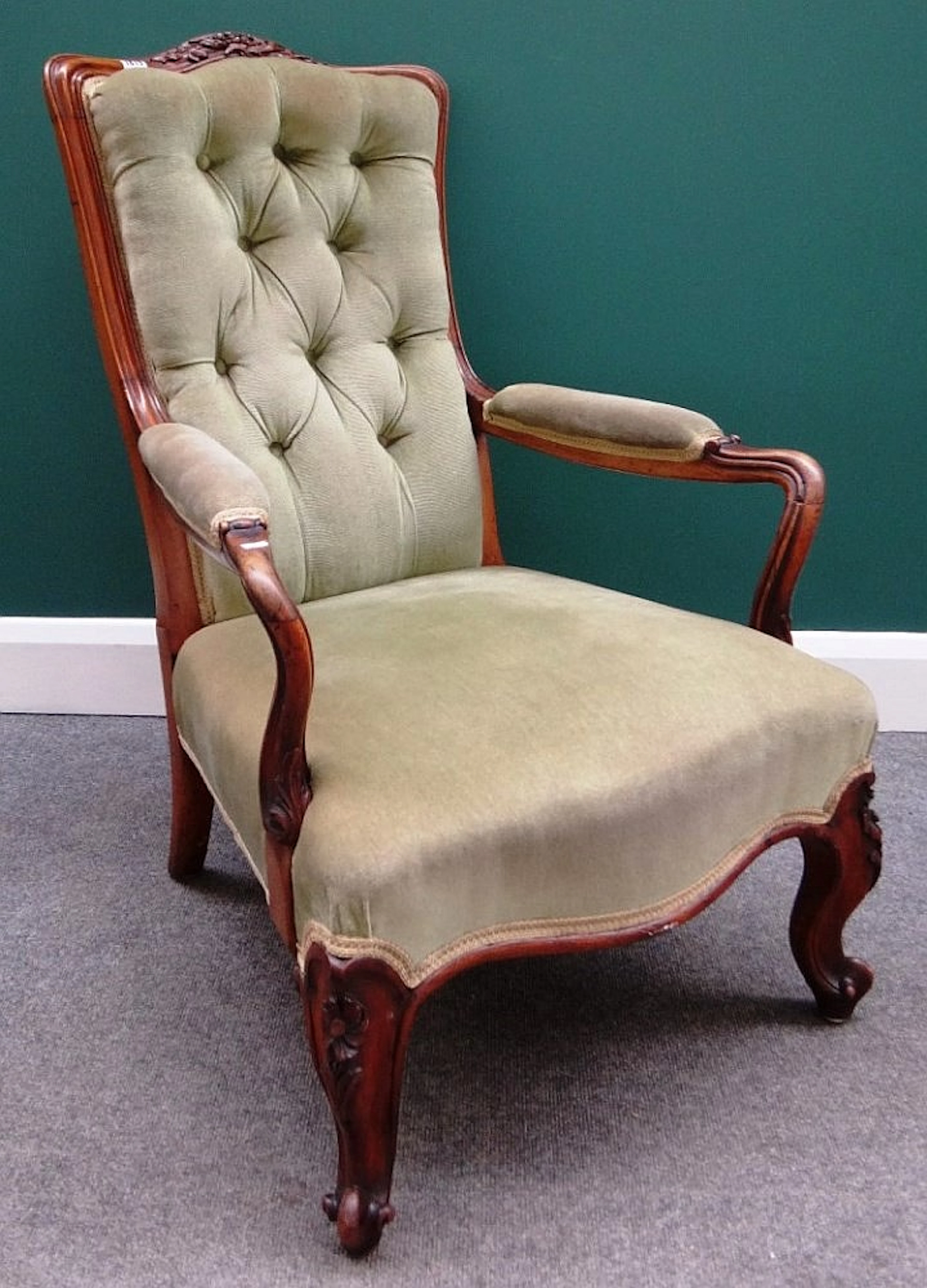 A Victorian walnut framed open armchair with serpentine seat on scroll supp