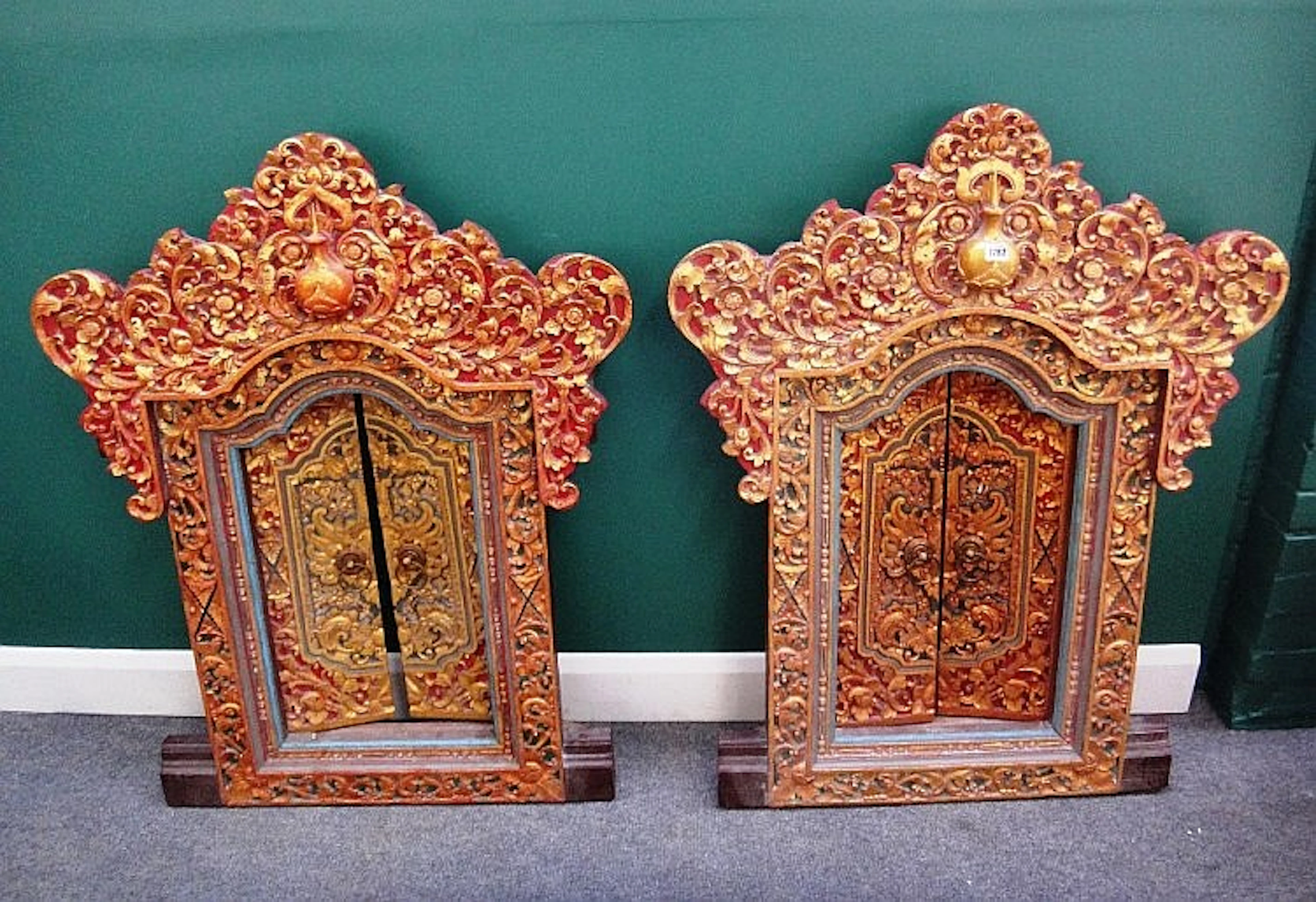 A pair of profusely carved, painted and gilded Tibetan windows, each with a