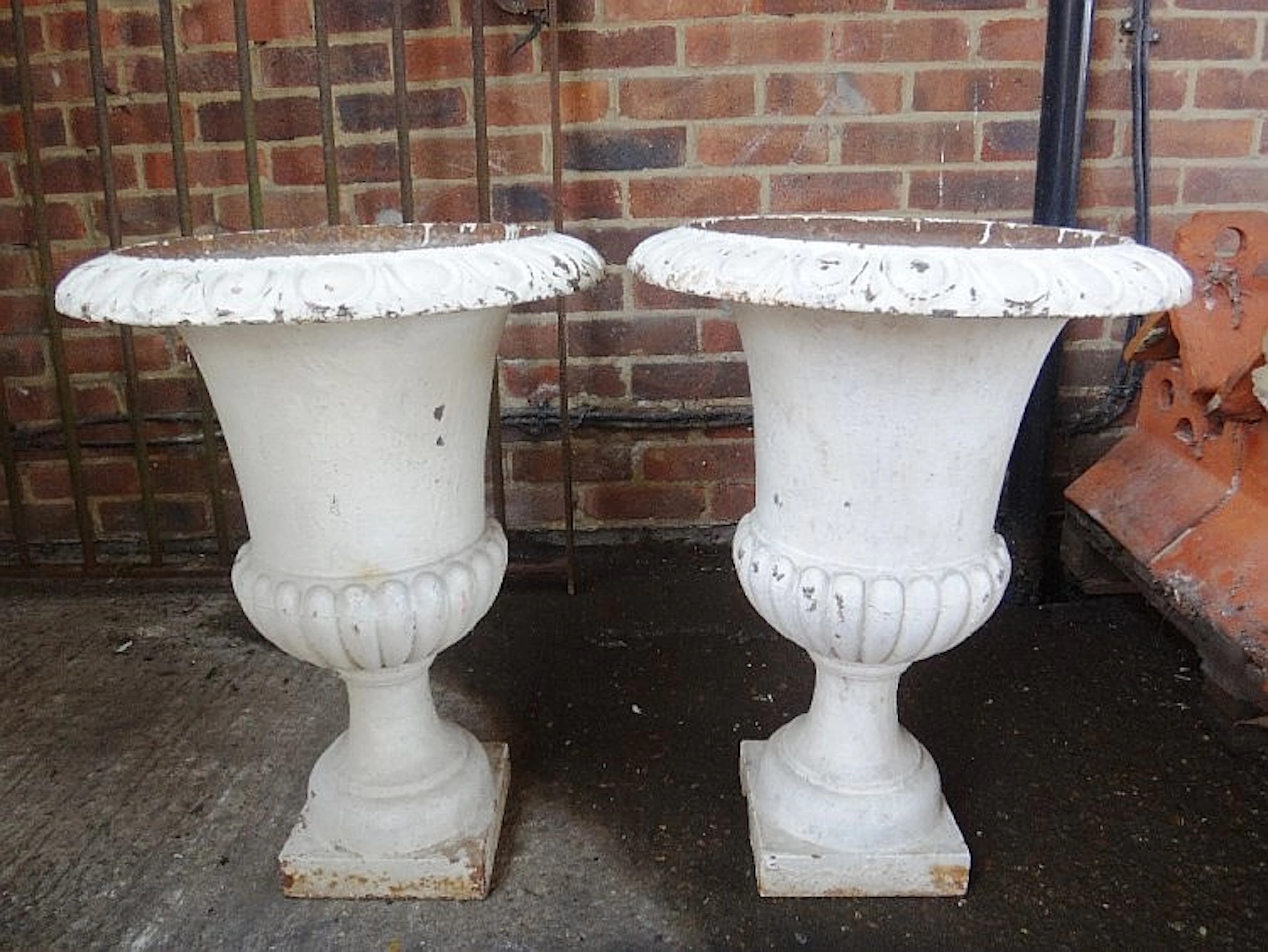 A pair of Victorian white painted cast iron planters, with semi-fluted bodi