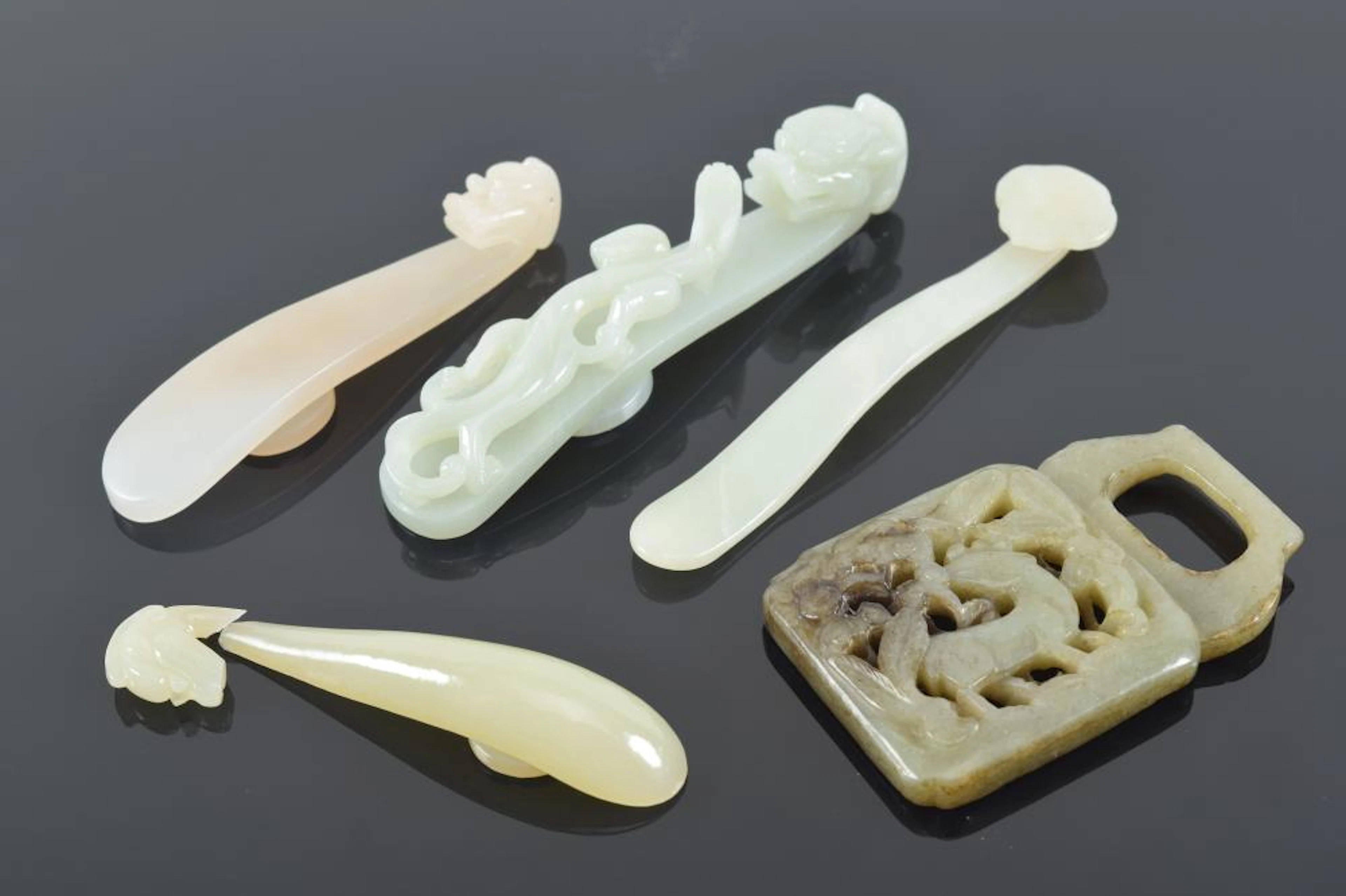 5 jades. China. 19th/20th century. Garment hooks, one damaged.