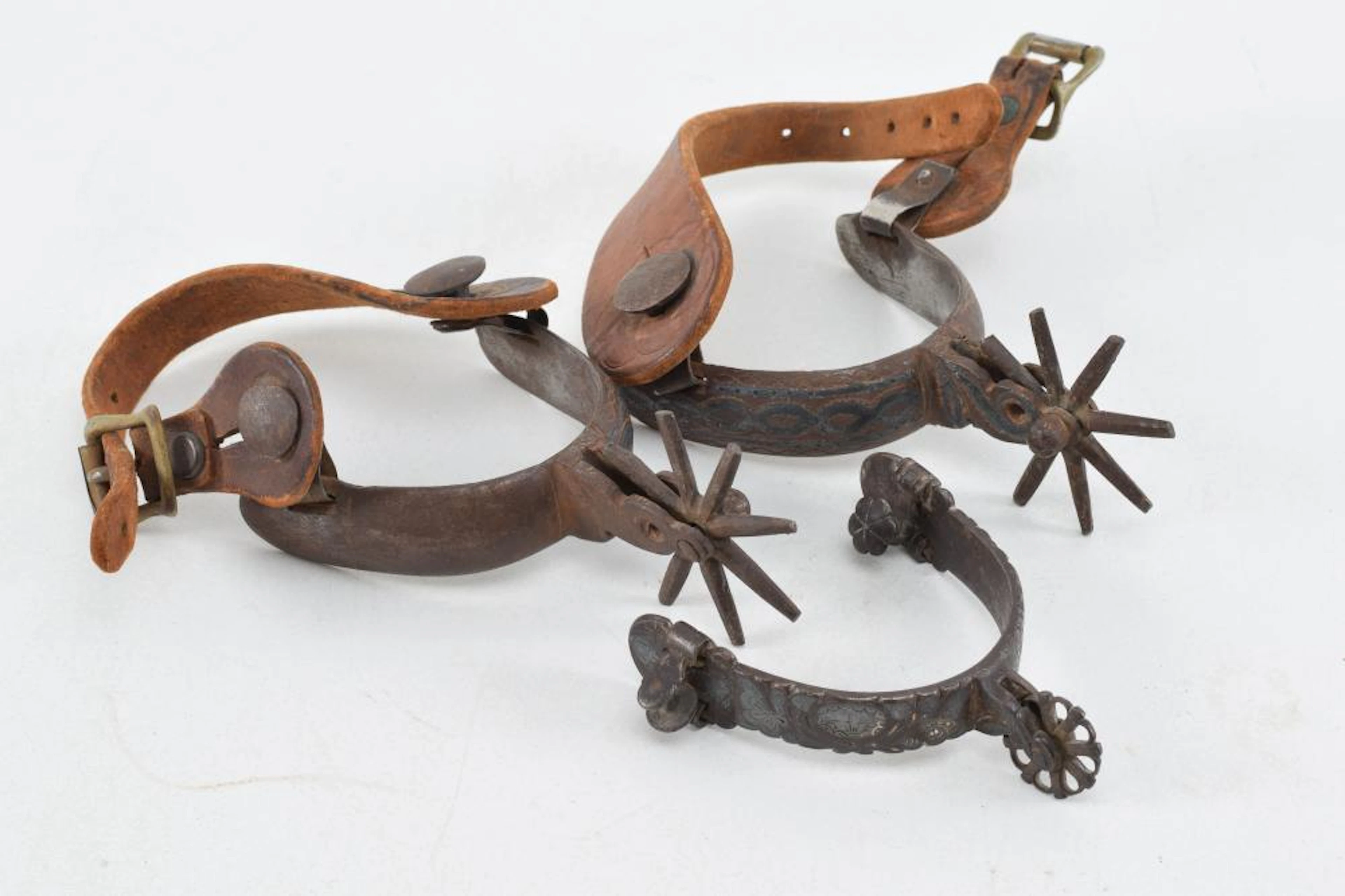 Pair of vintage iron spurs with leather straps.