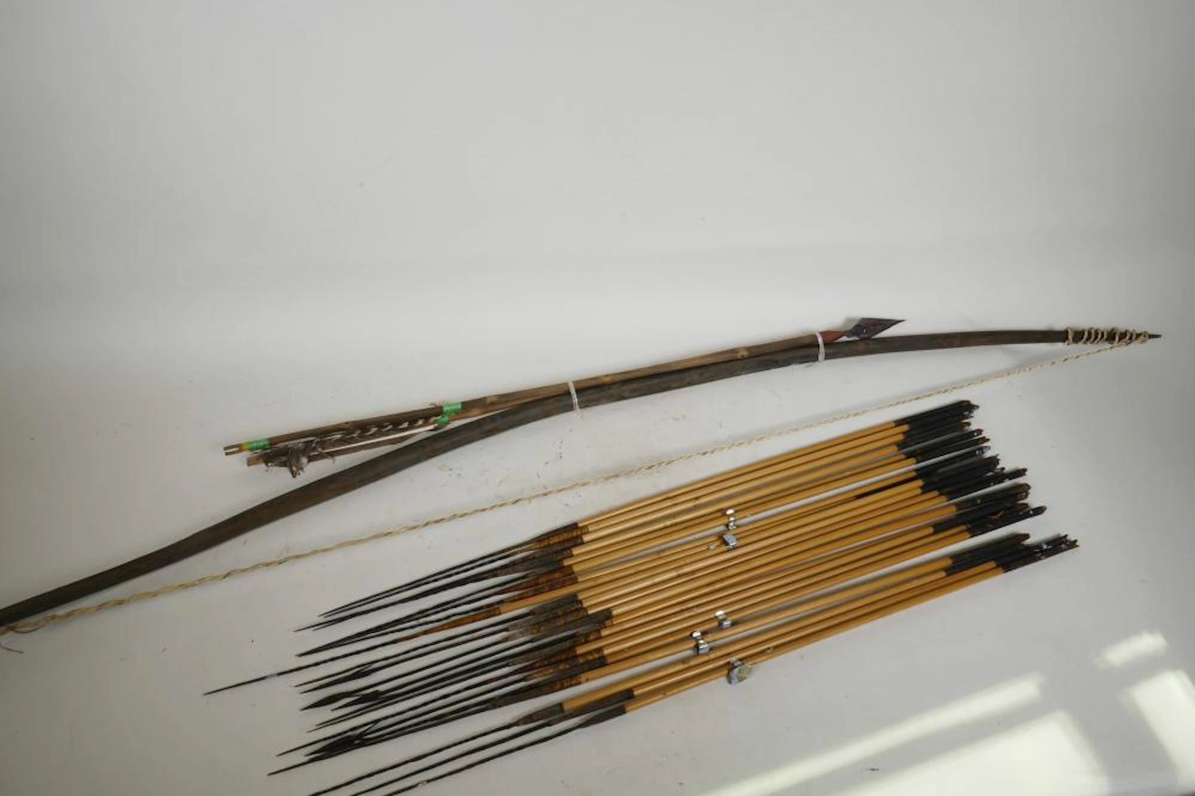A wooden bow and twenty three bamboo hunting arrows from Papua New Guinea