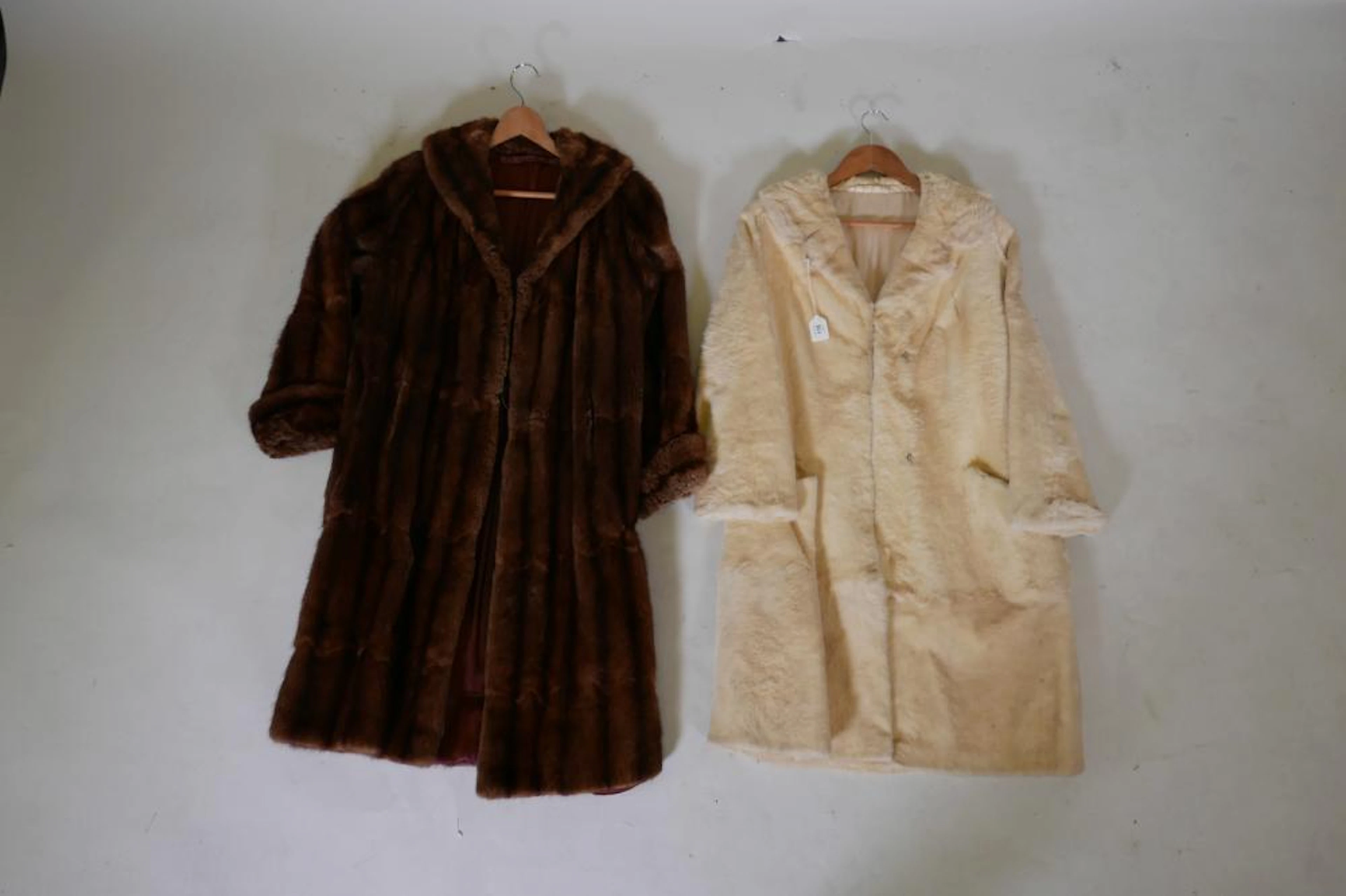 A lady's three quarter length fur coat and another white fur coat