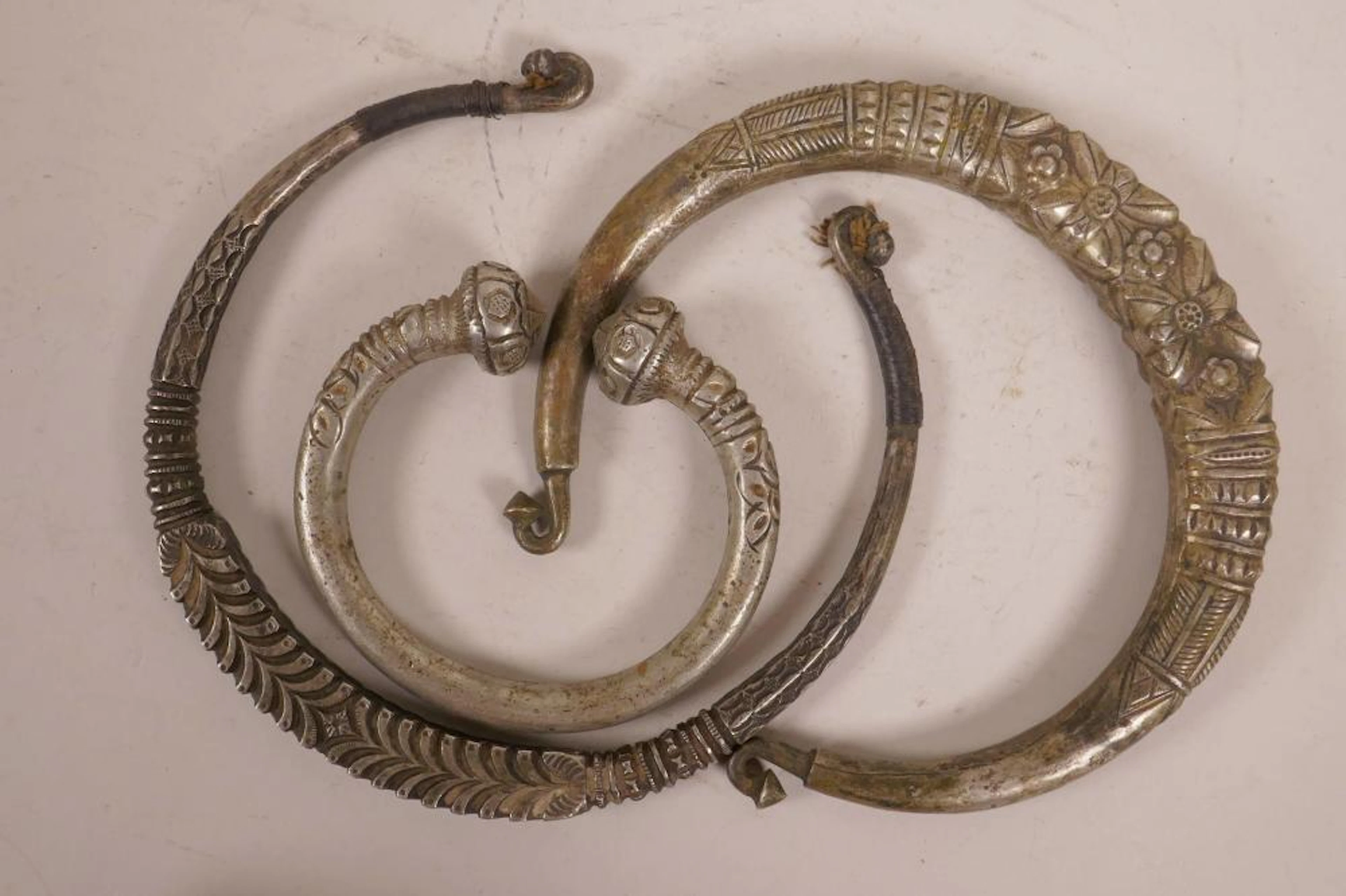 Three Tibetan torc necklaces, largest 7½" diameter