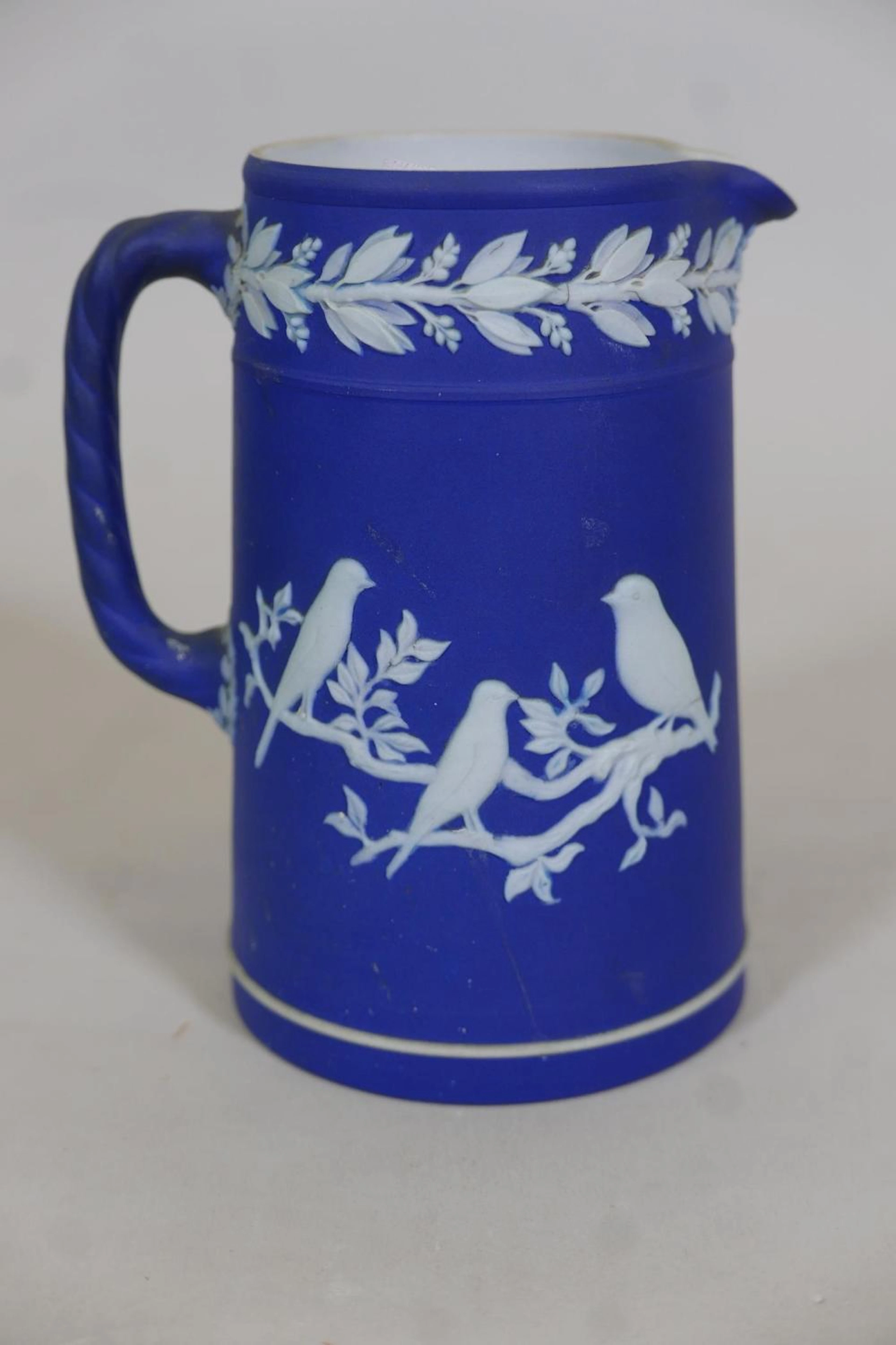 A Wedgwood blue Jasperware jug with raised bird decoration, 6½" high