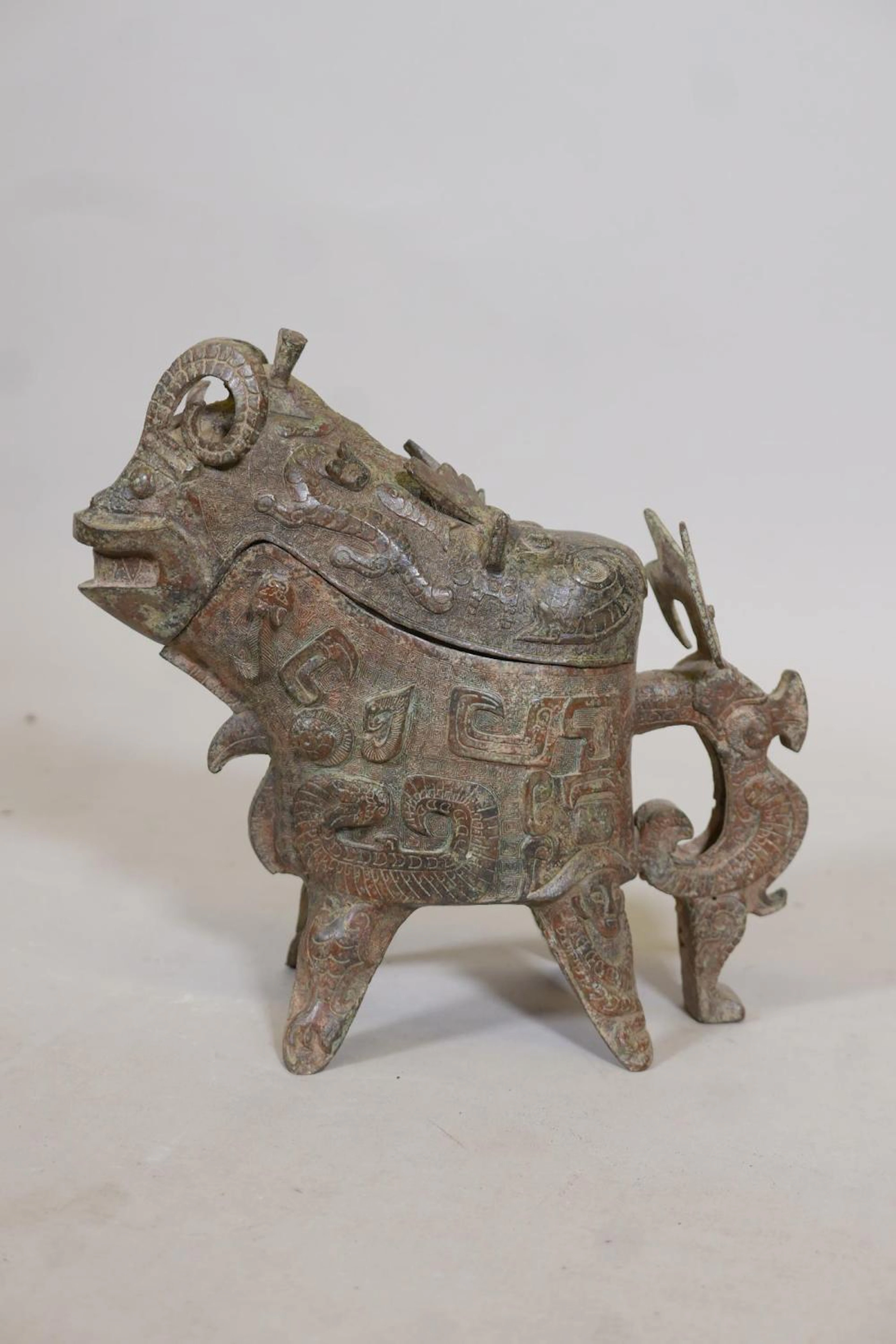 A Chinese bronze vessel and cover in the form of a ram