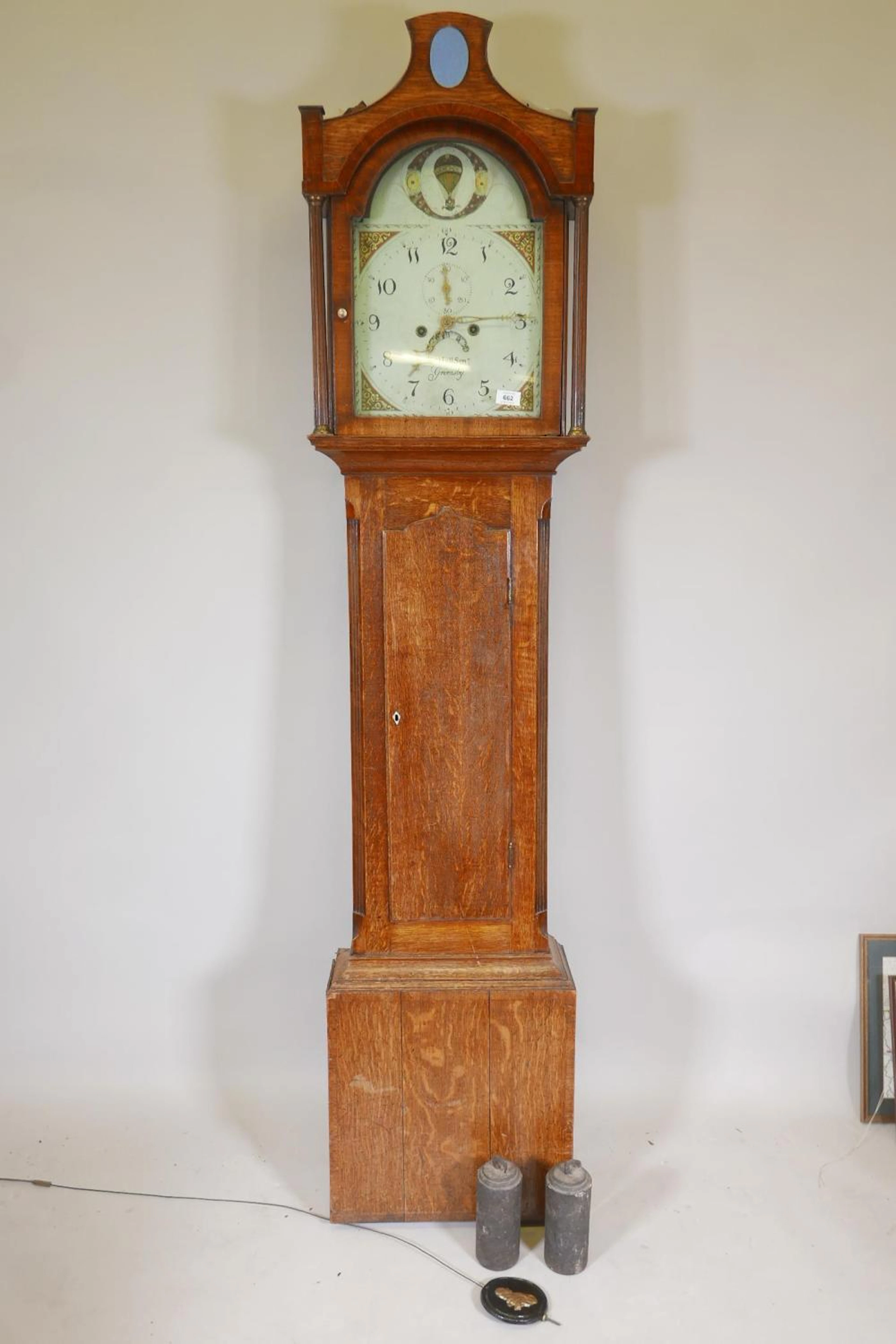 An early C19th oak long case clock, the arched dial painted with a balloo
