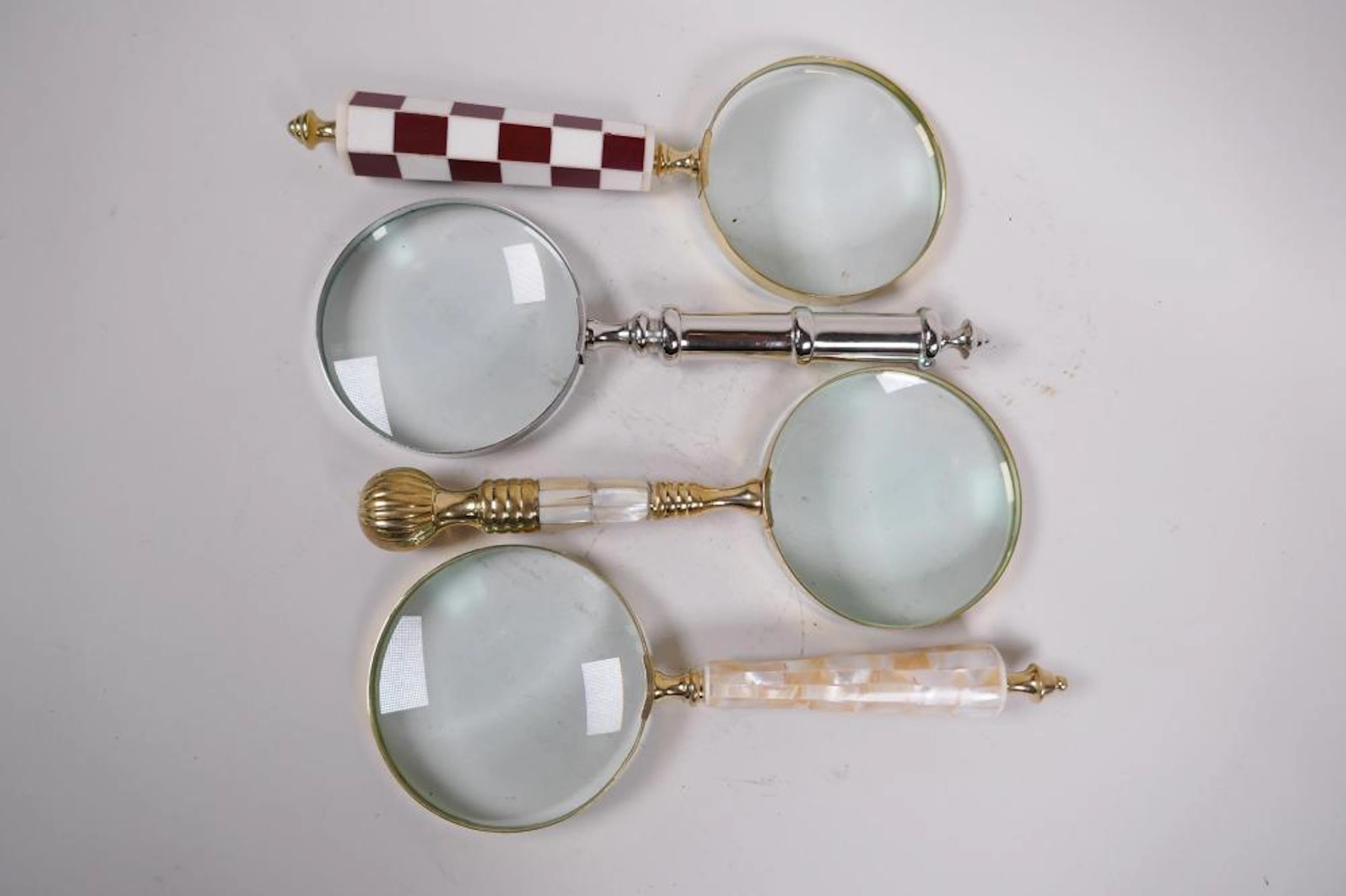Four various desk top magnifying glasses, lenses 4" diameter