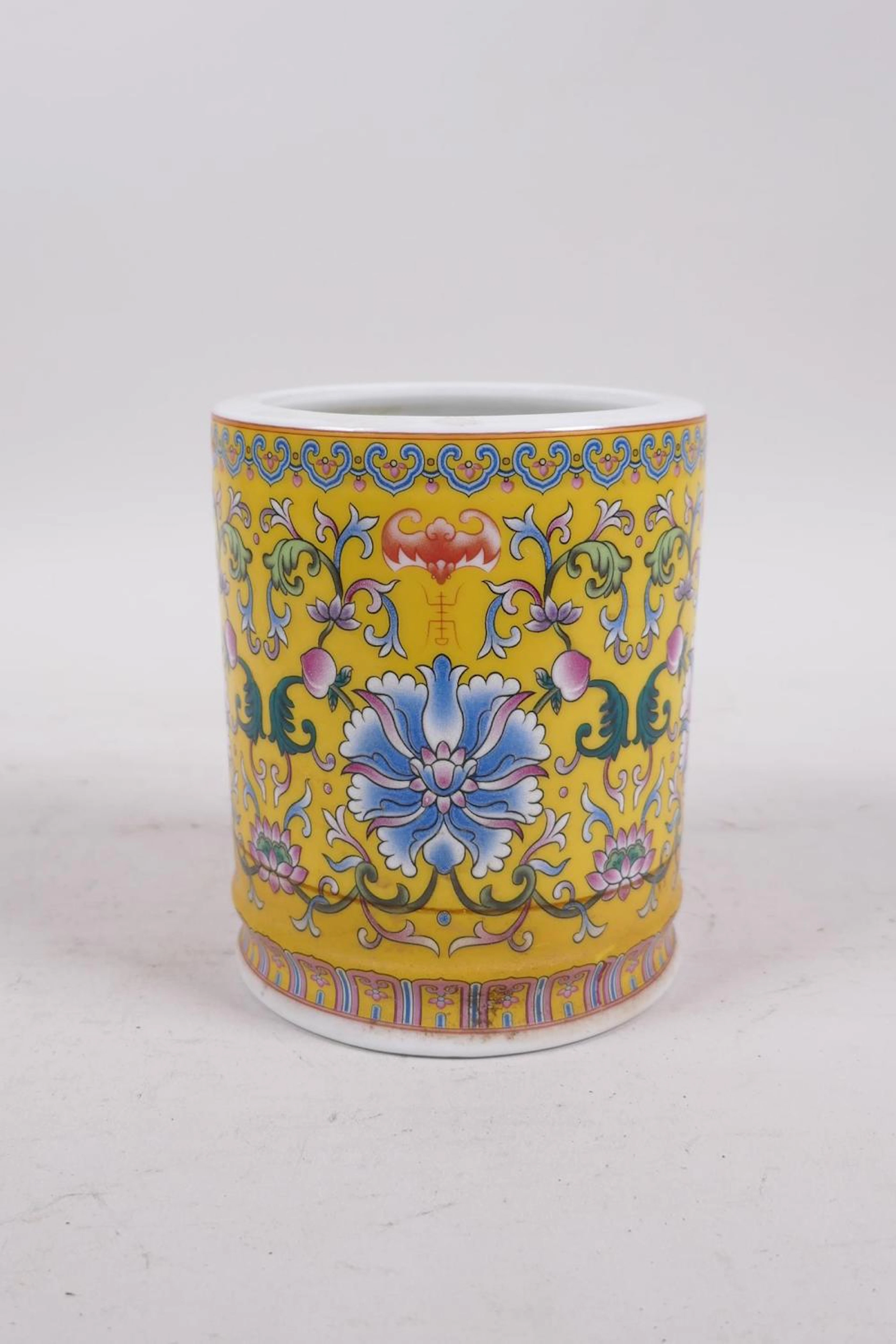 A Chinese yellow ground porcelain brush pot with...