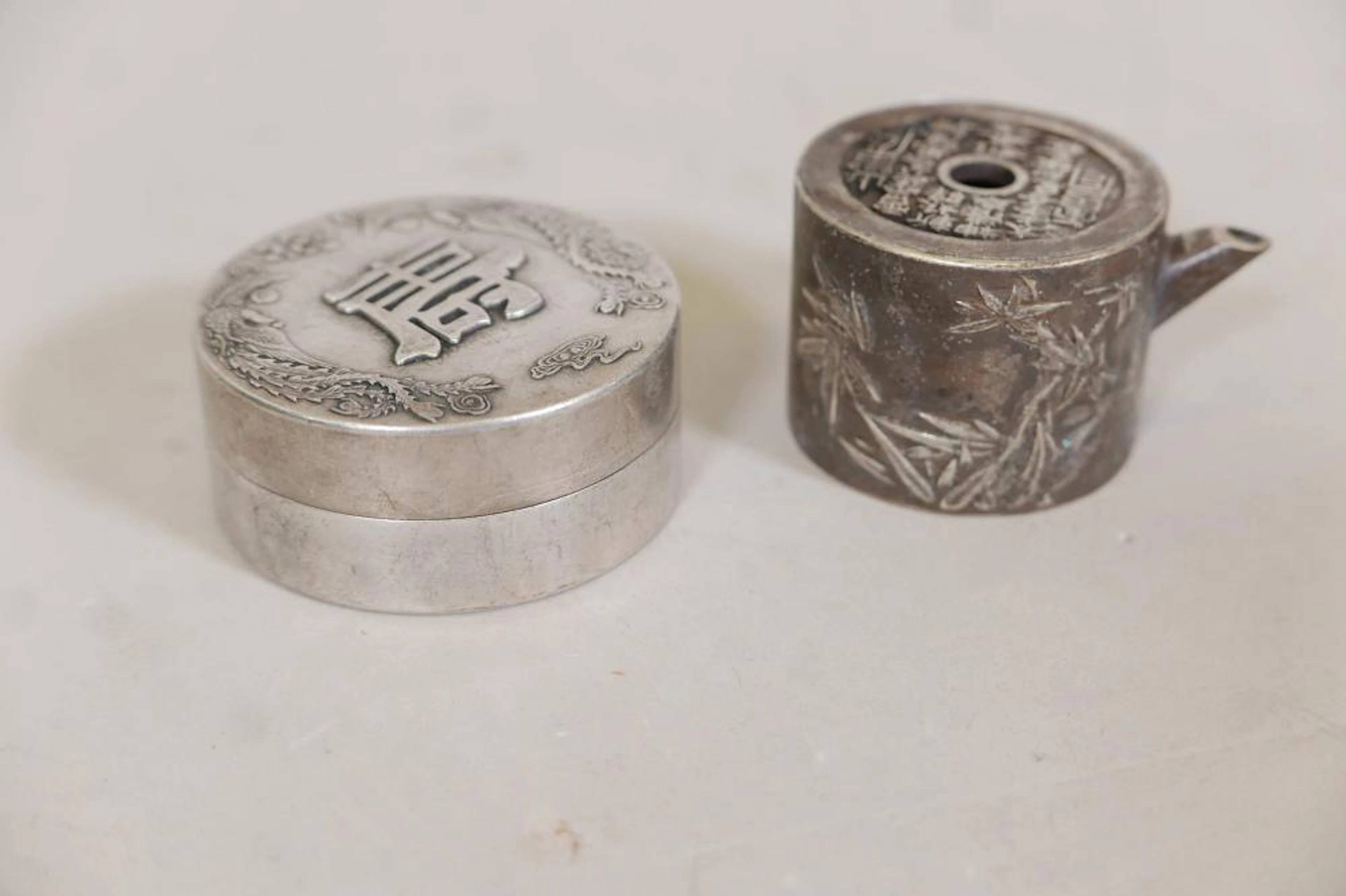 A Chinese white metal jar and cover with raised decoration