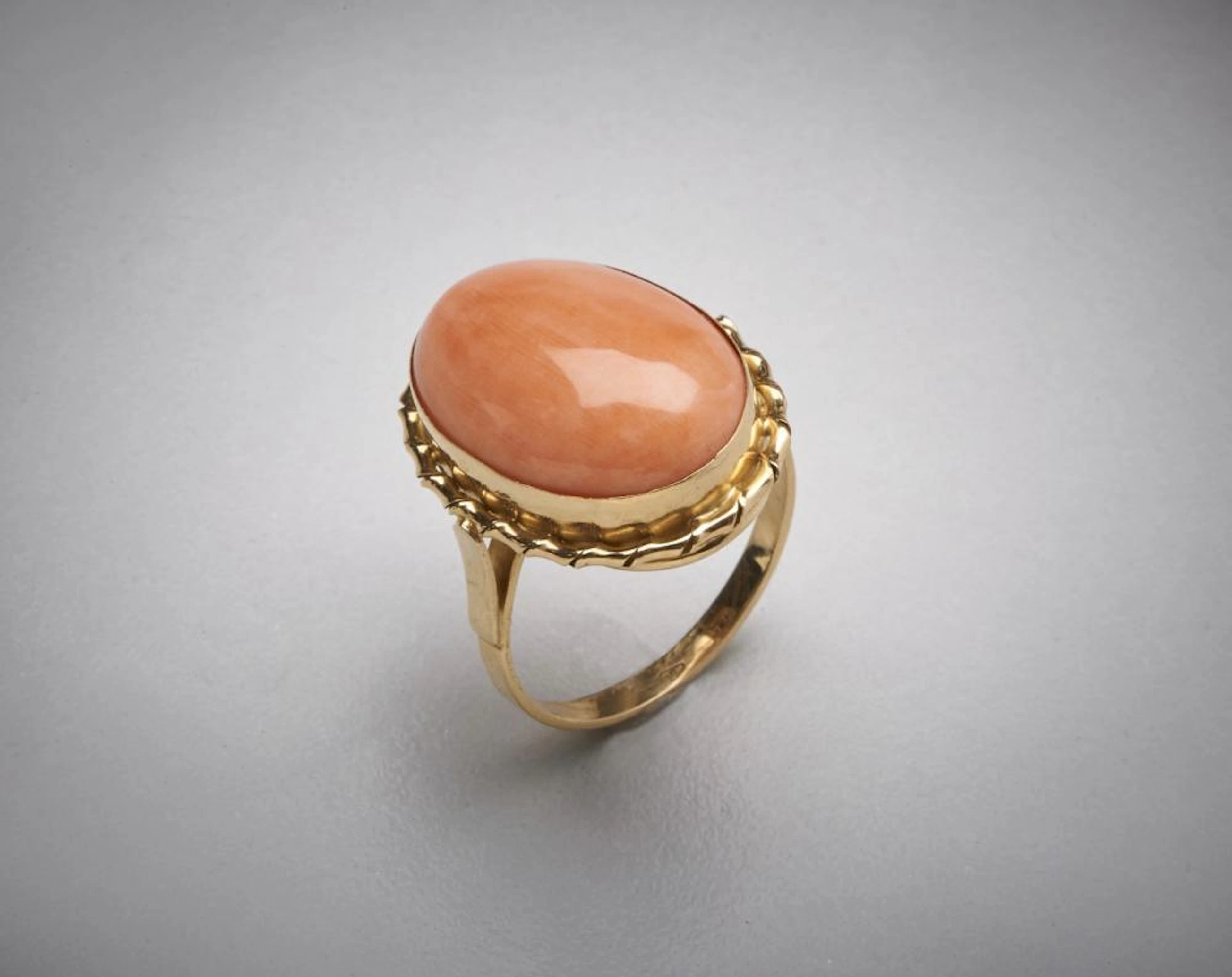 Anello in oro giallo 750/1000 con corallo rosa cabochon. Peso lordo 7,10.