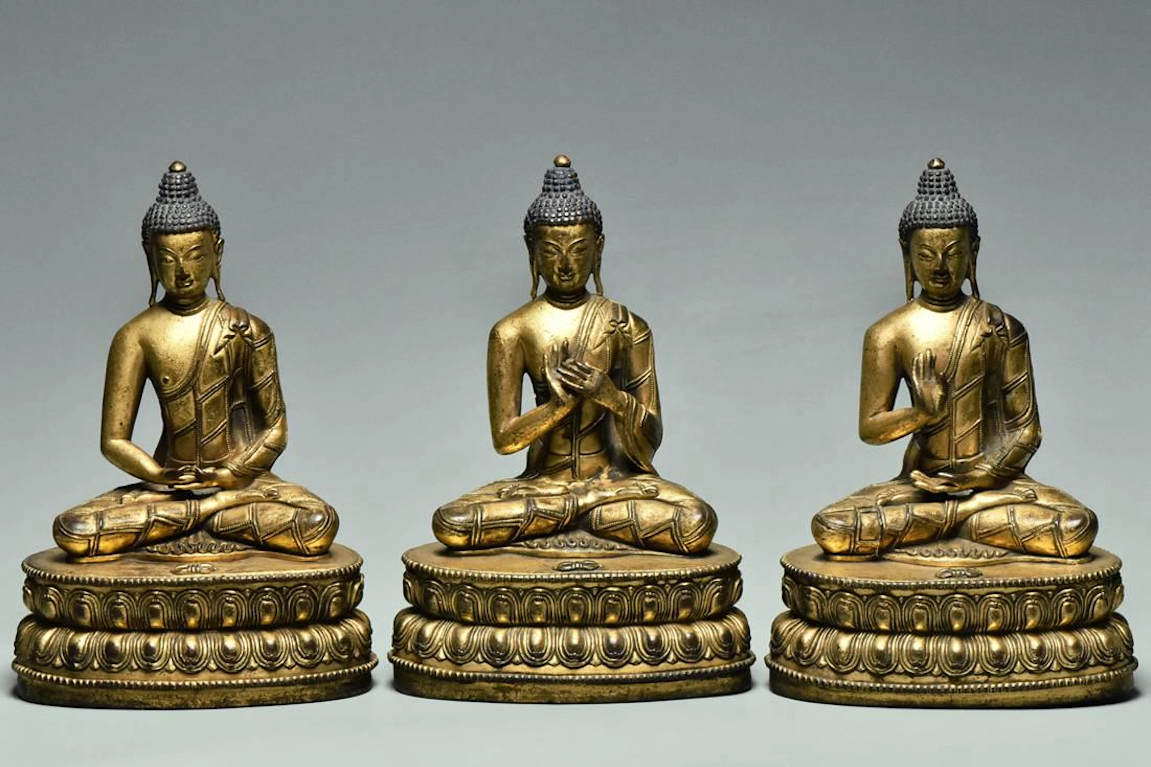 Set of three gilt bronze figures of buddha 15th c