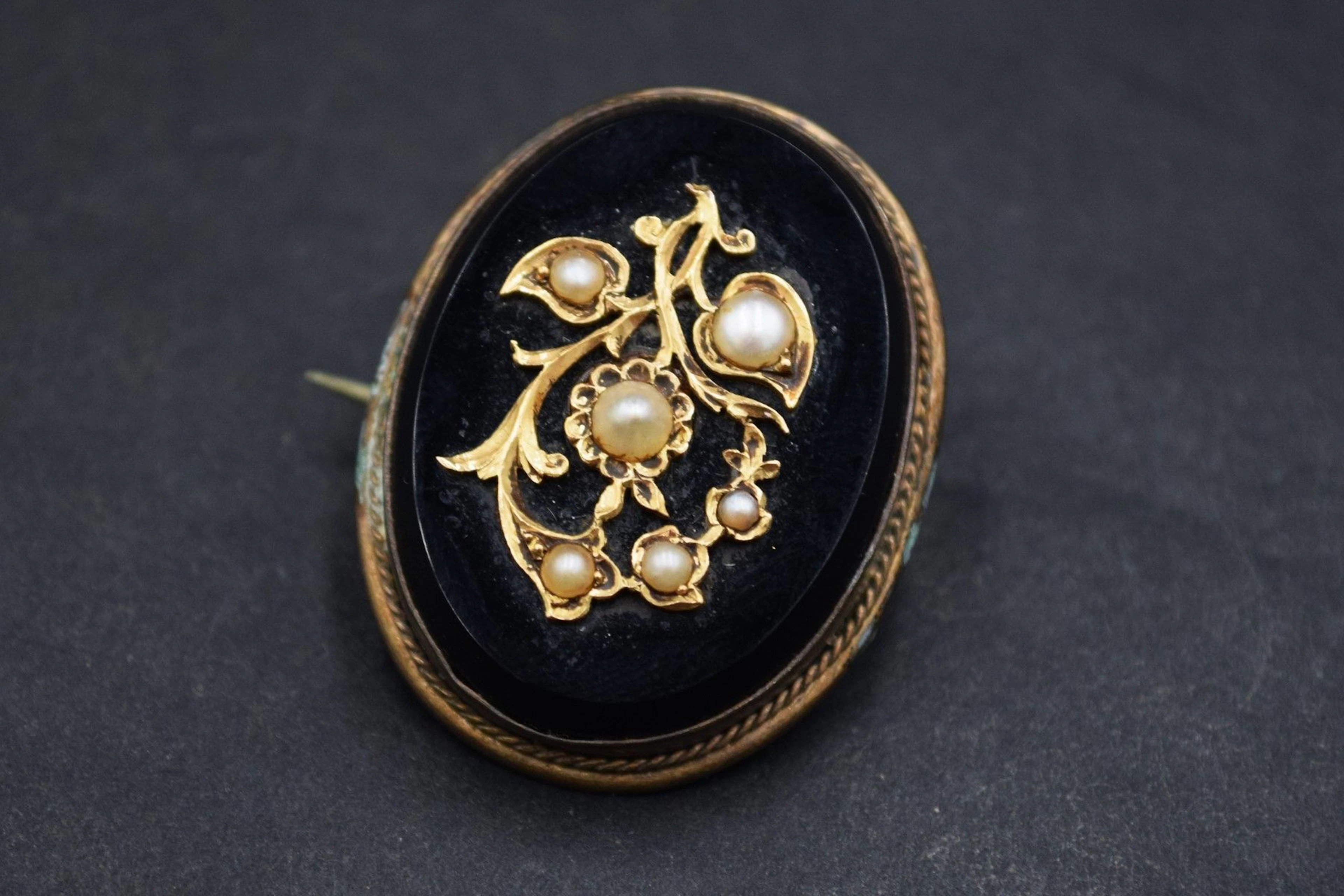Broche en métal retenant un plaque d'onyx... - Lot 365 - Rossini