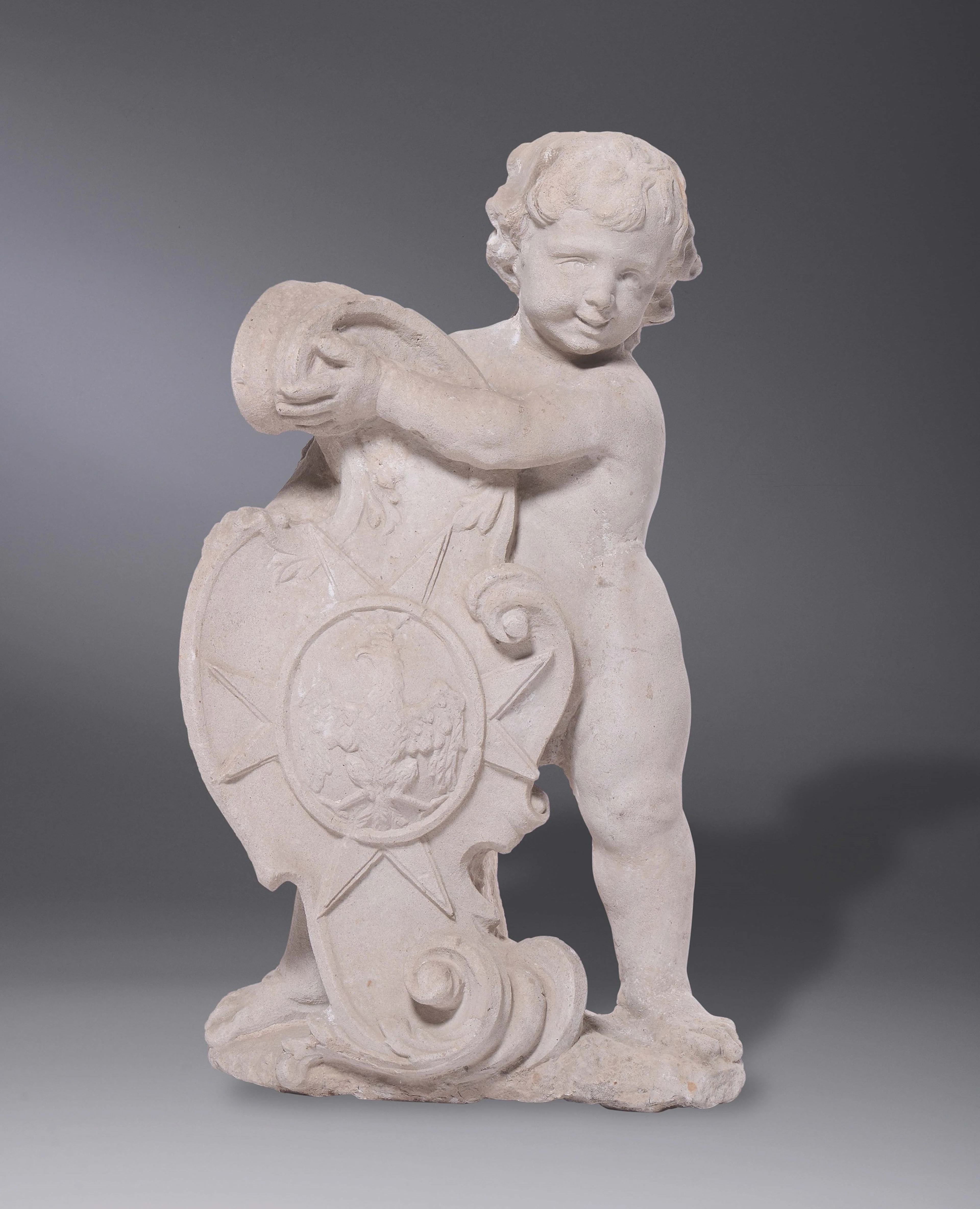 A stone sculpture with a little angel holding a crest, 17th century