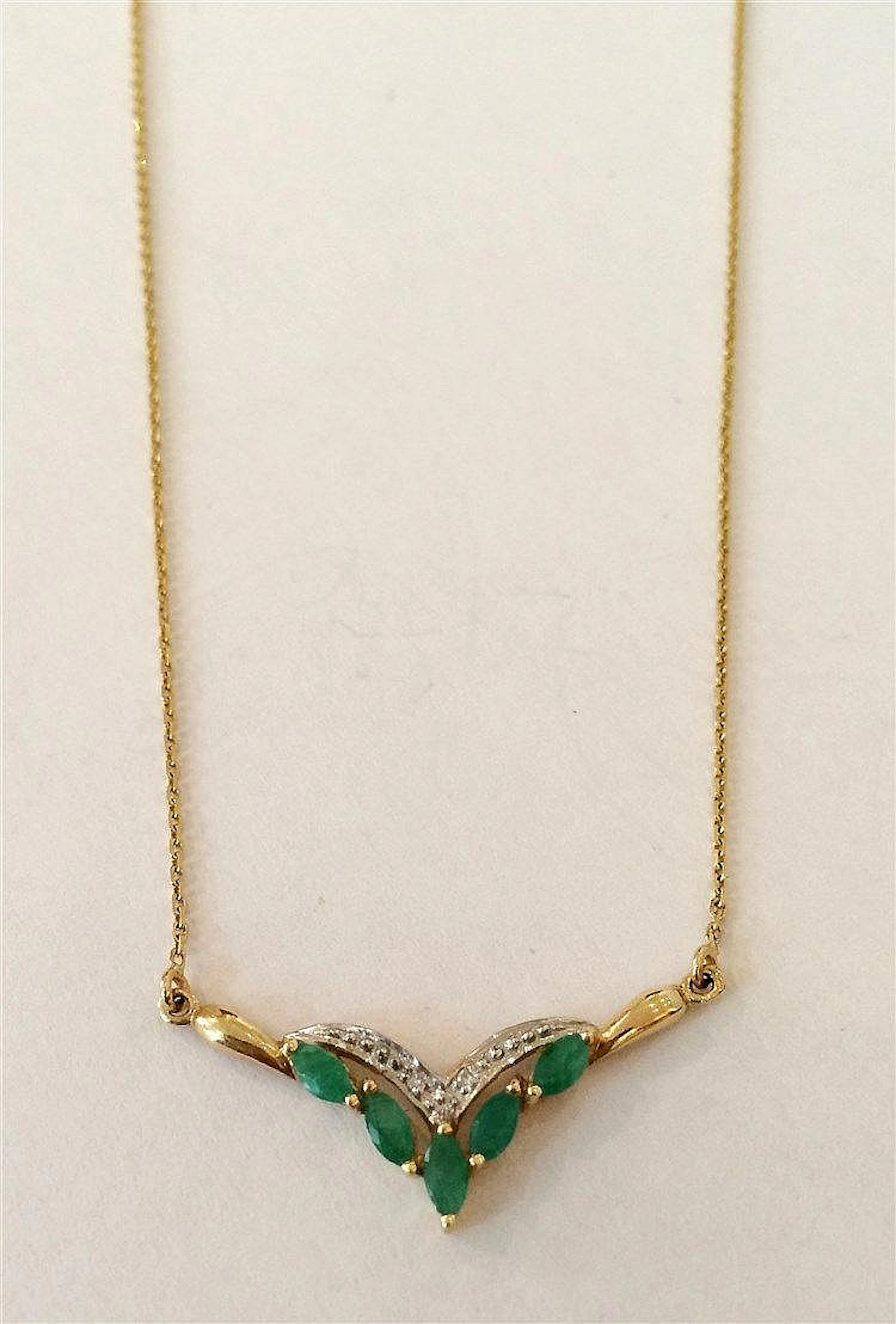 Collier en or jaune à décor en chute de petites emeraudes taille