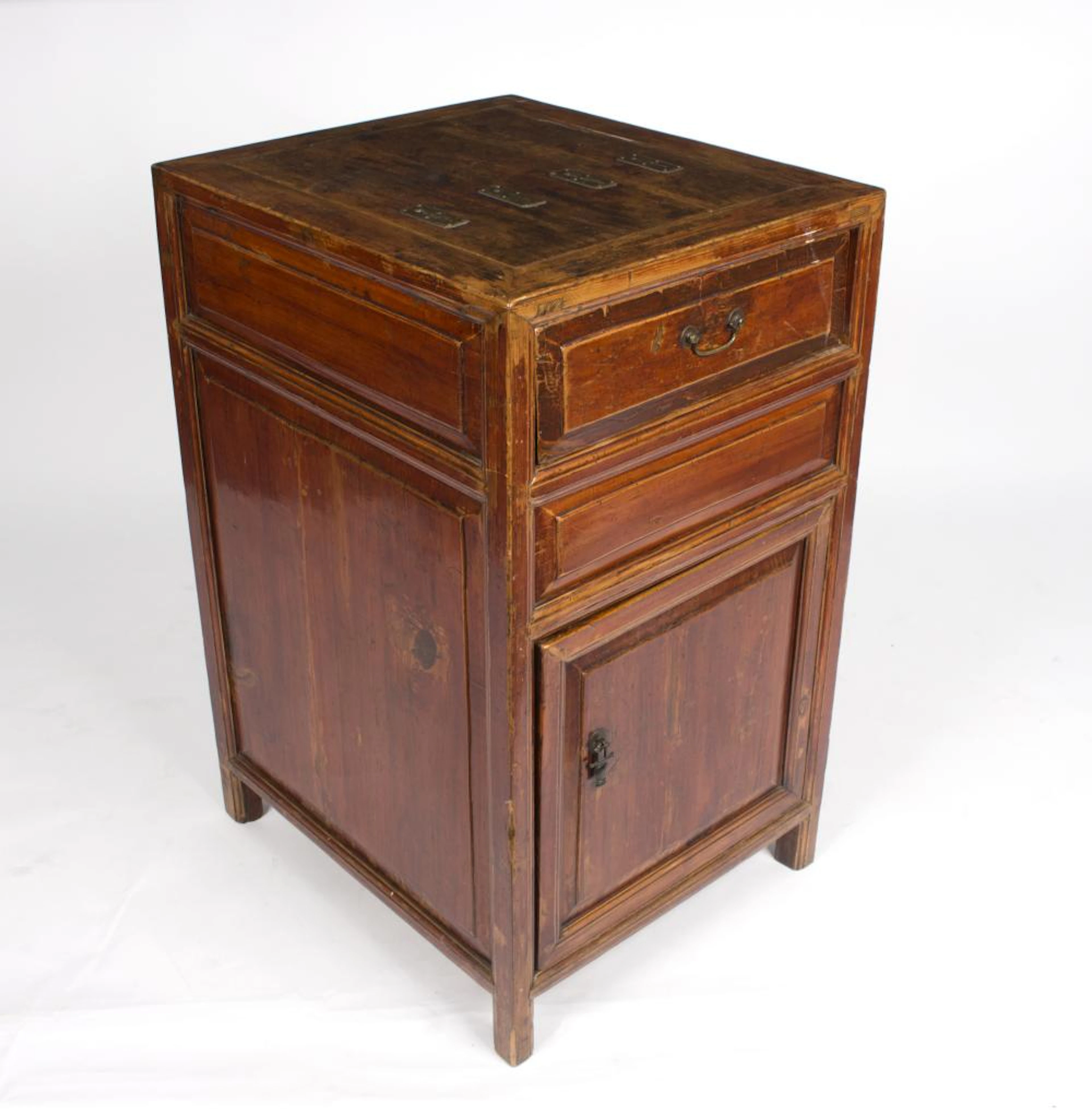 An Indonesian chest with cupboard and drawer and coin slots to the top