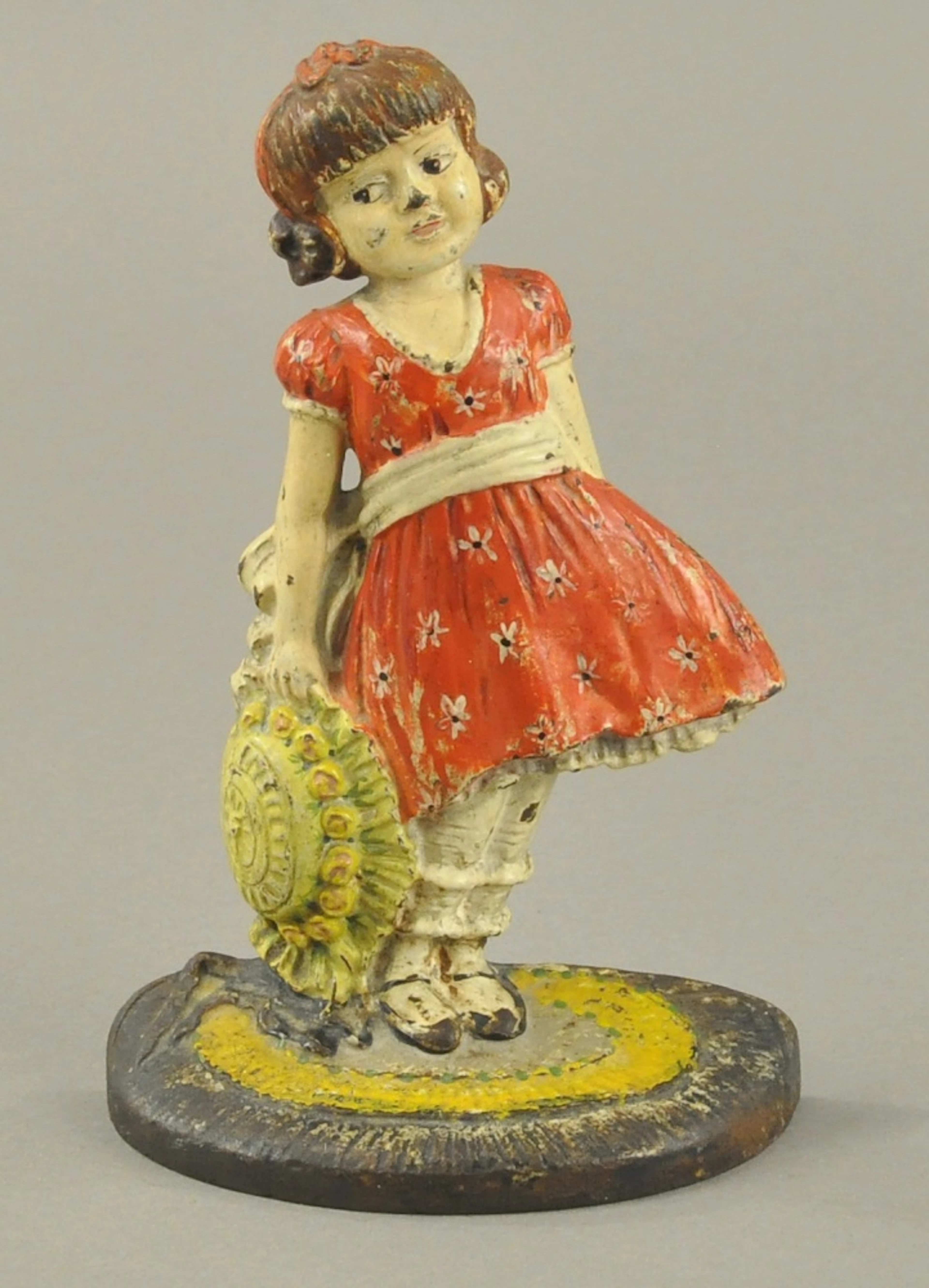 GIRL HOLDING BONNET DOORSTOP
