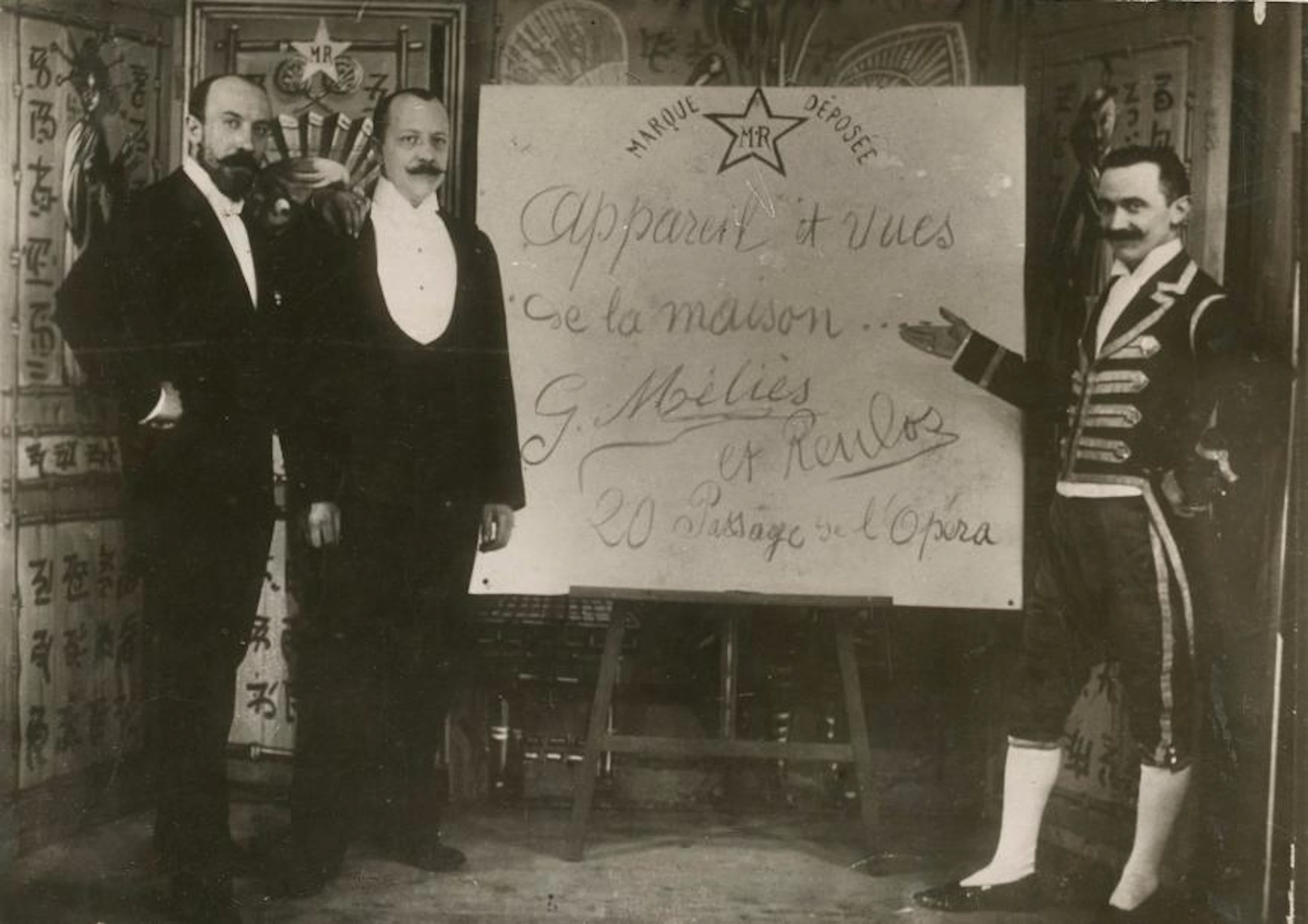 Georges Méliès et Lucien Eugène Reulos Devant leur panneau publicitaire
