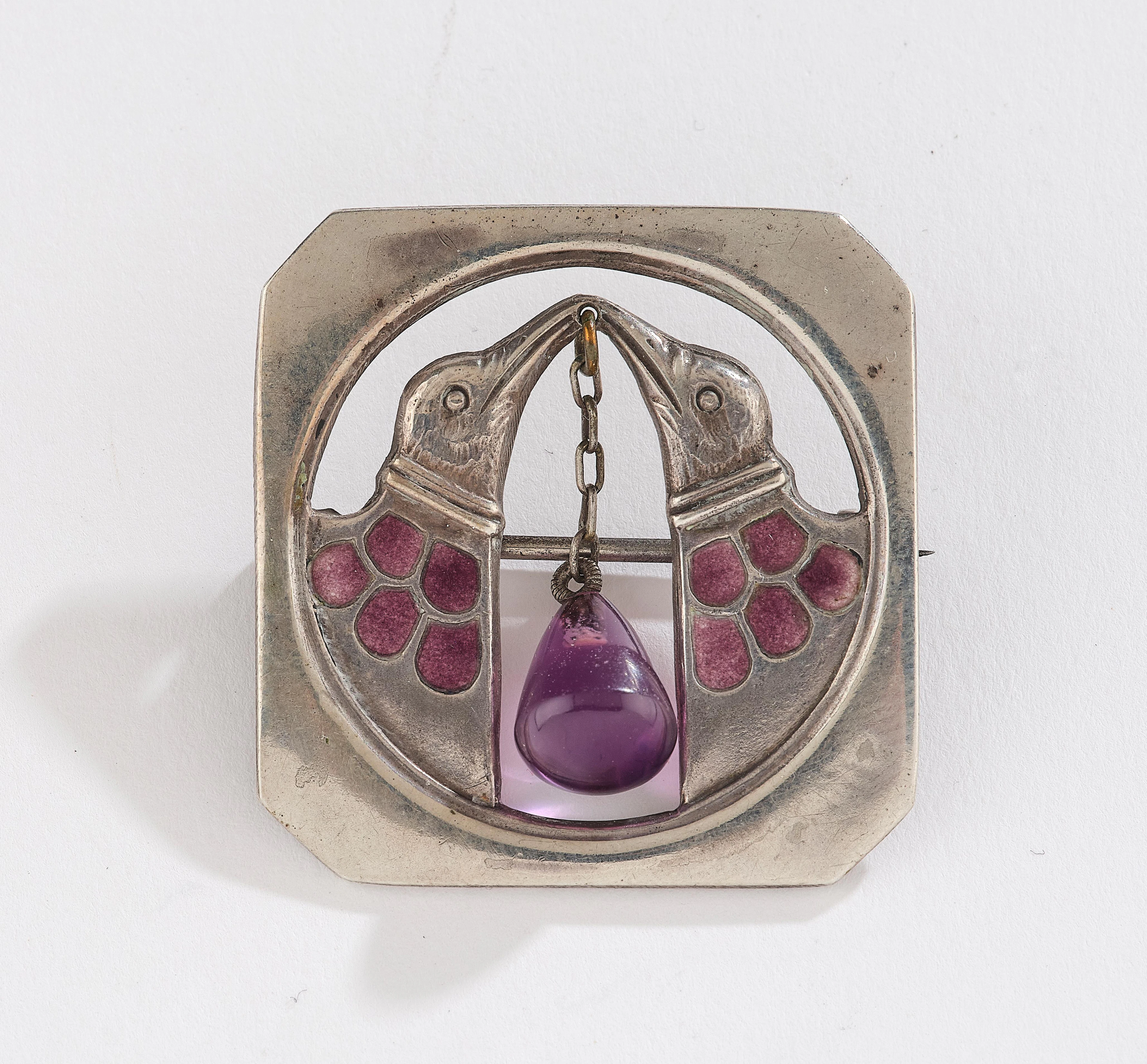 A silver brooch with birds and amethyst