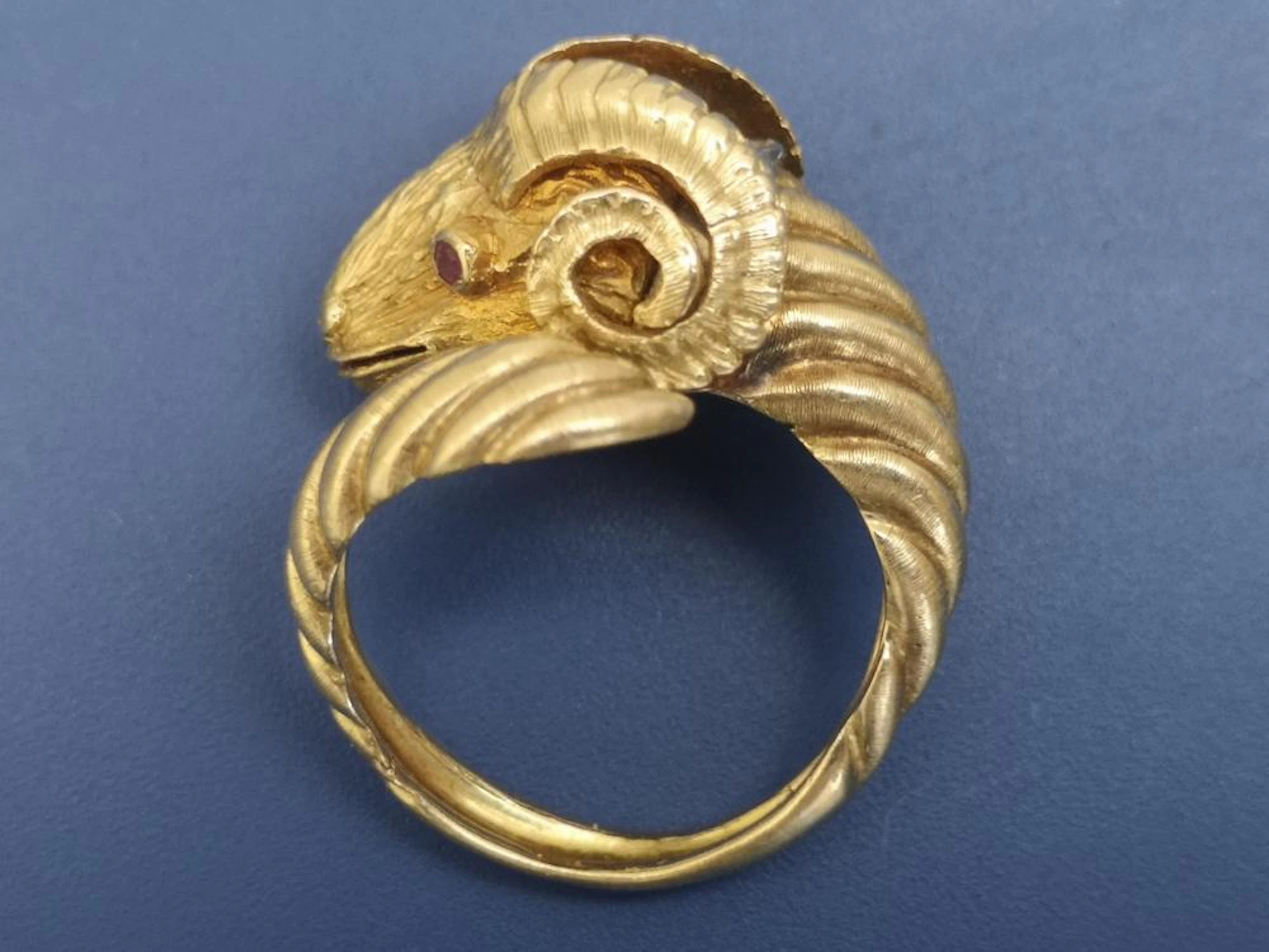 An 18ct gold ram's head ring by Lalounis, having a small rose cut diamond o