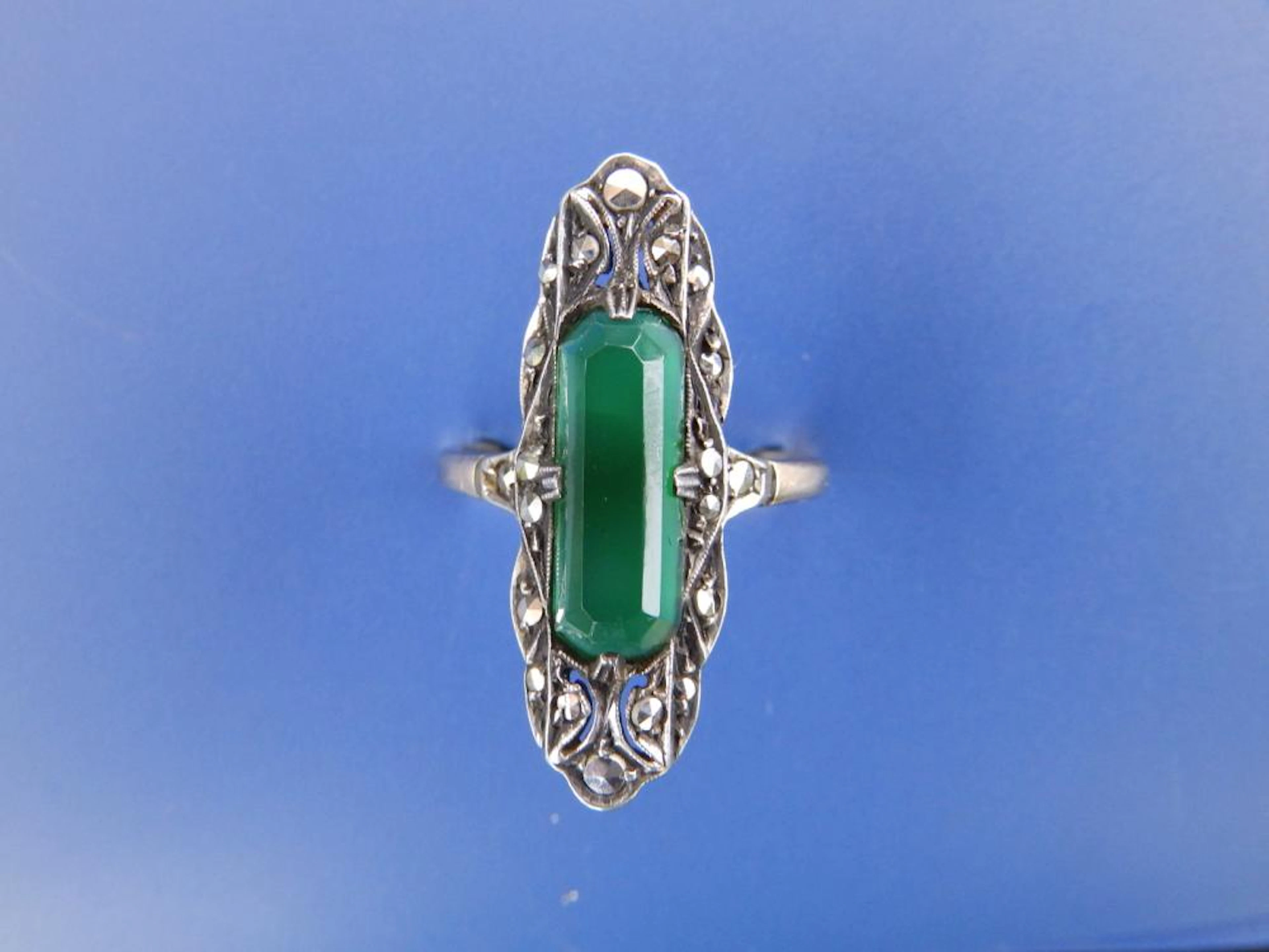 An art deco dress ring set with an elongated green