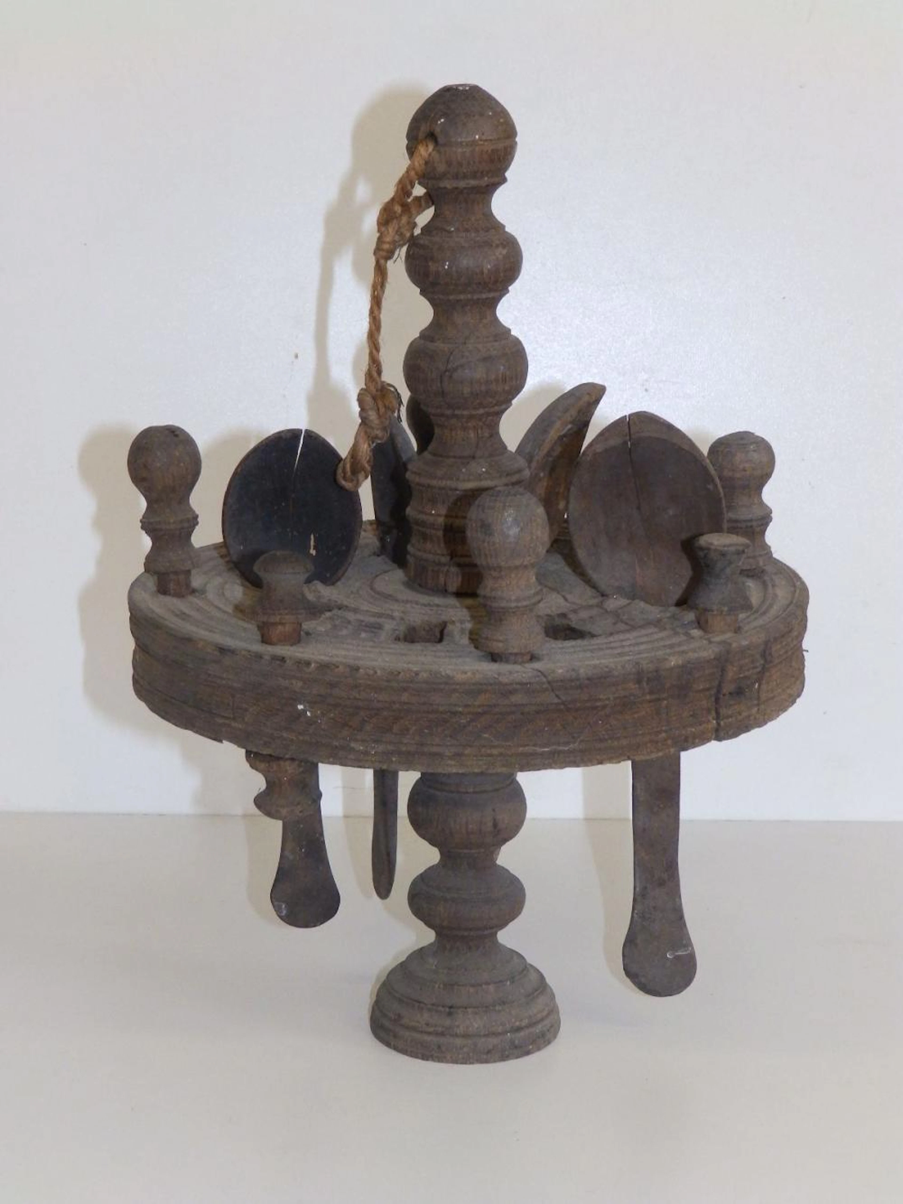 An antique revolving wooden spoon rack with four spoons, 12" high - a/f.