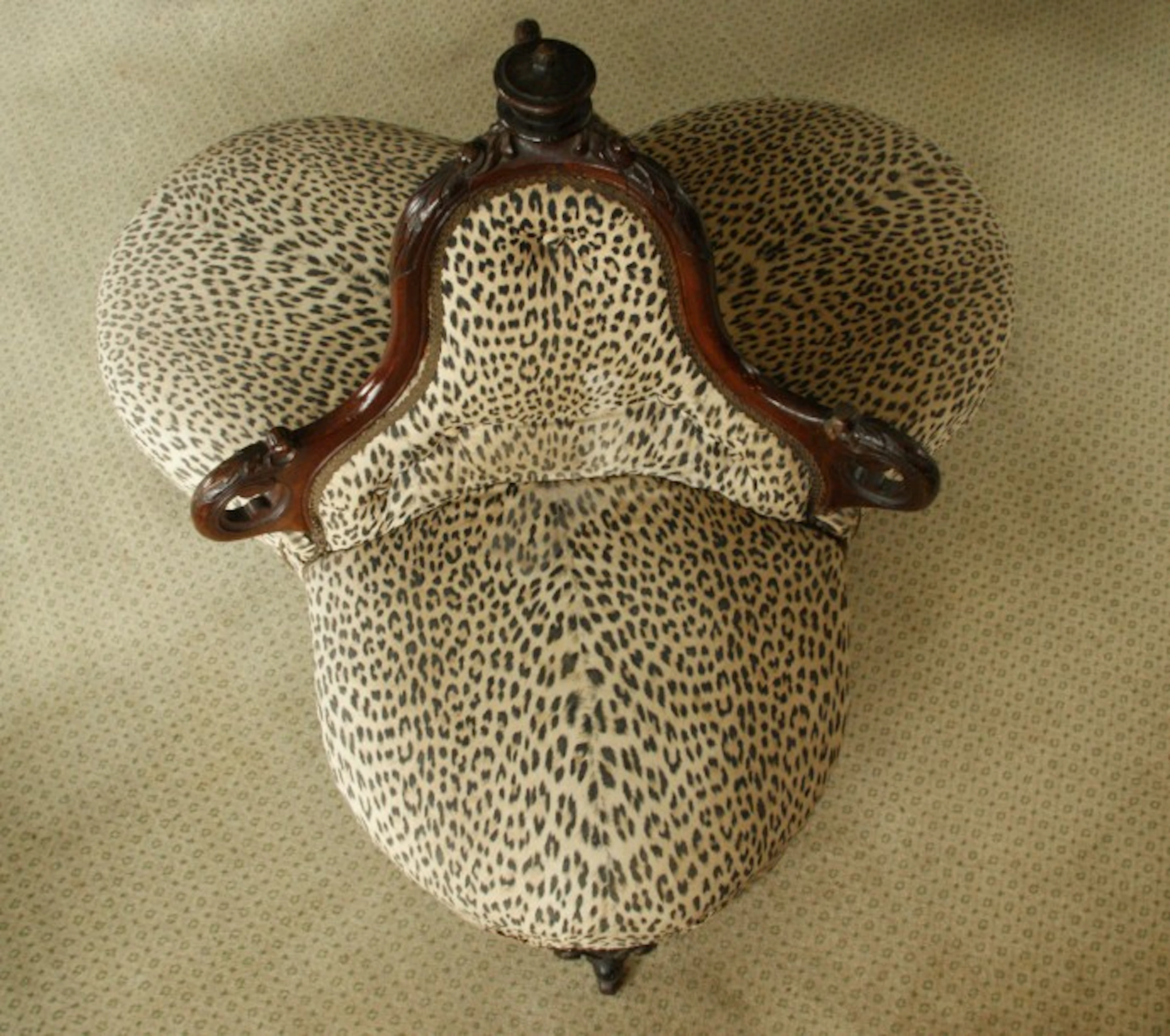 Causeuse en acajou garnie d’un tissu motif panthère pied