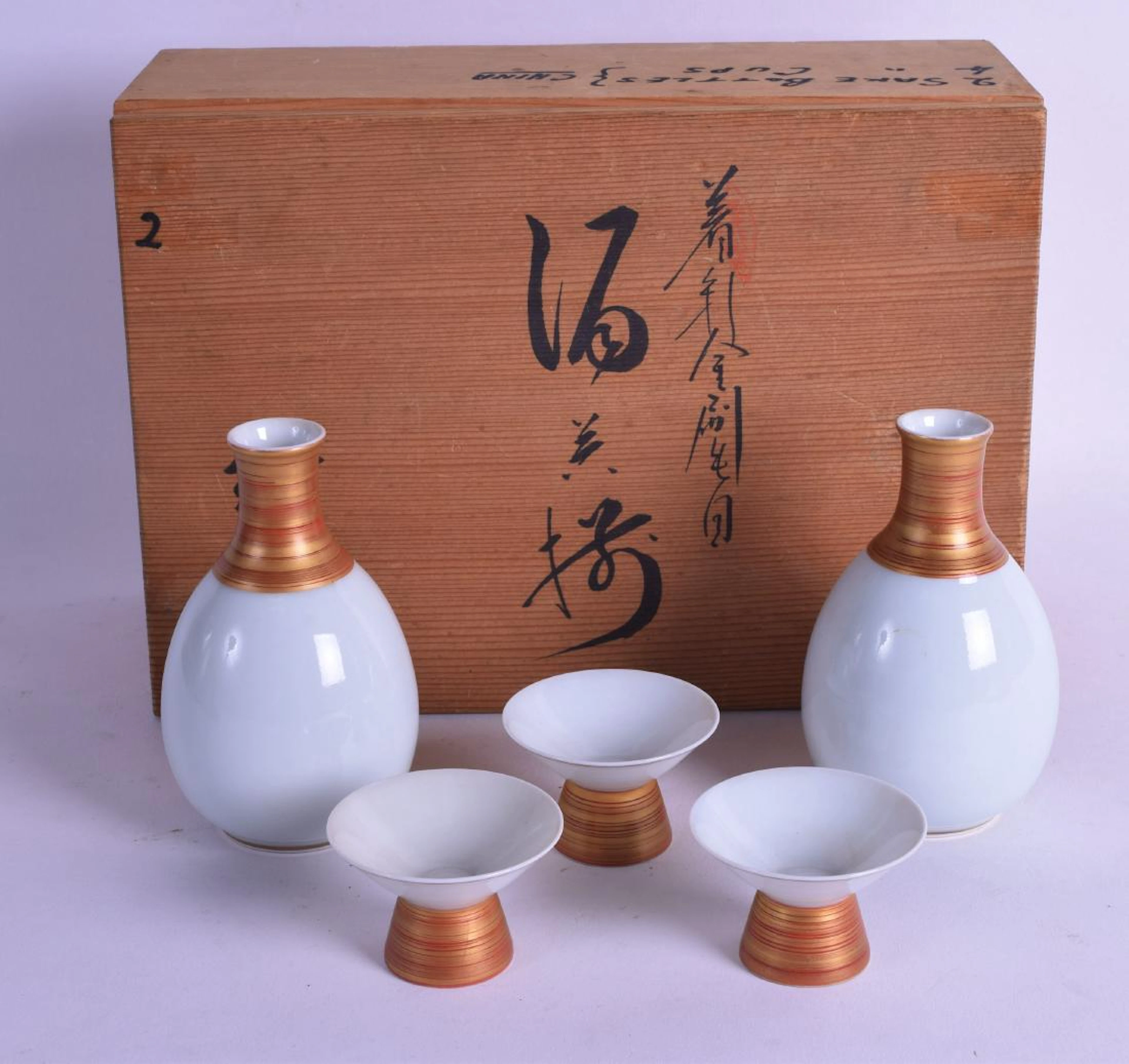 A boxed japanese taisho period porcelain sake set.