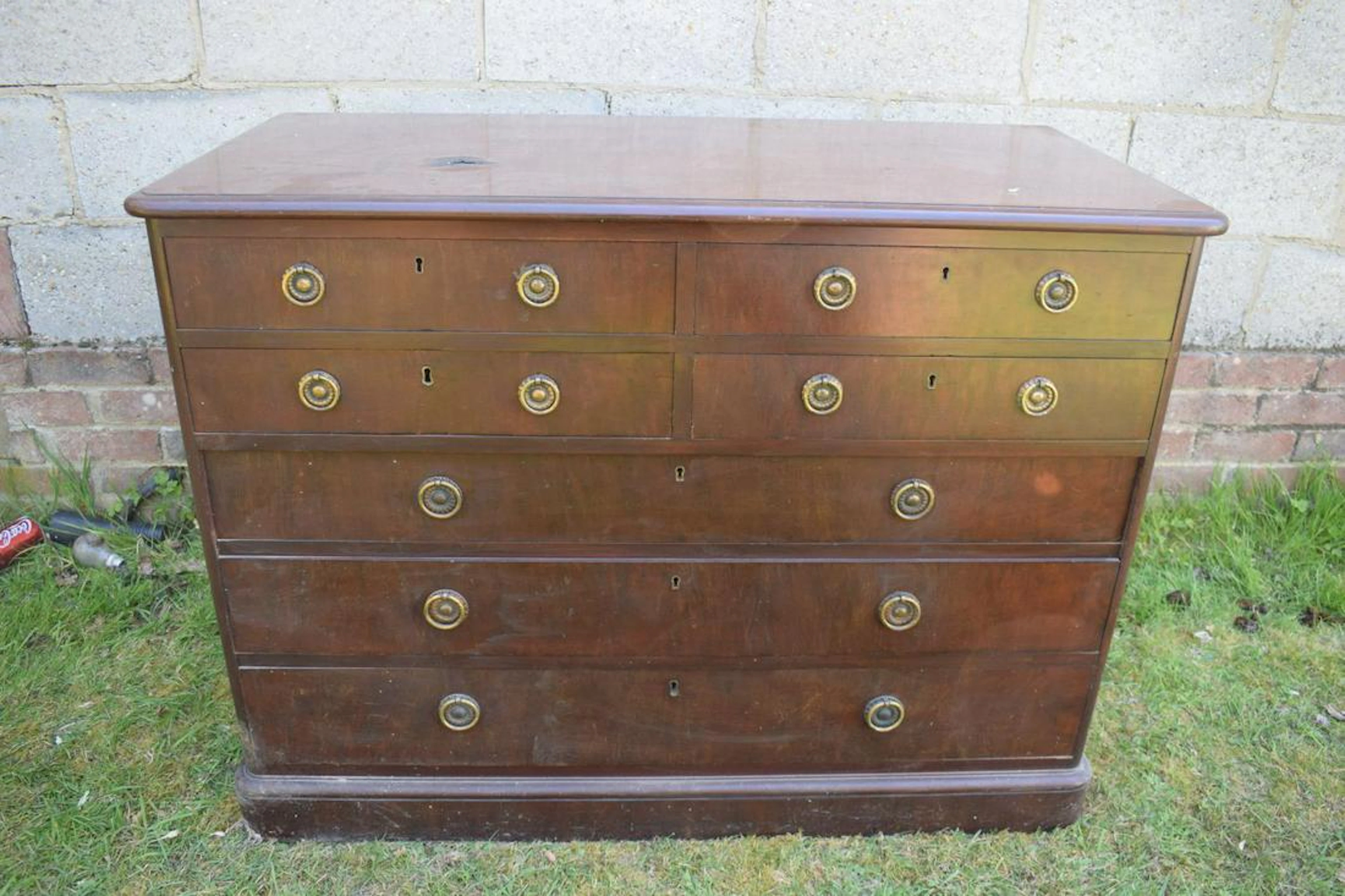 AN ANTIQUE PLUM MAHOGANY SEVEN DRAWER CHEST with brass