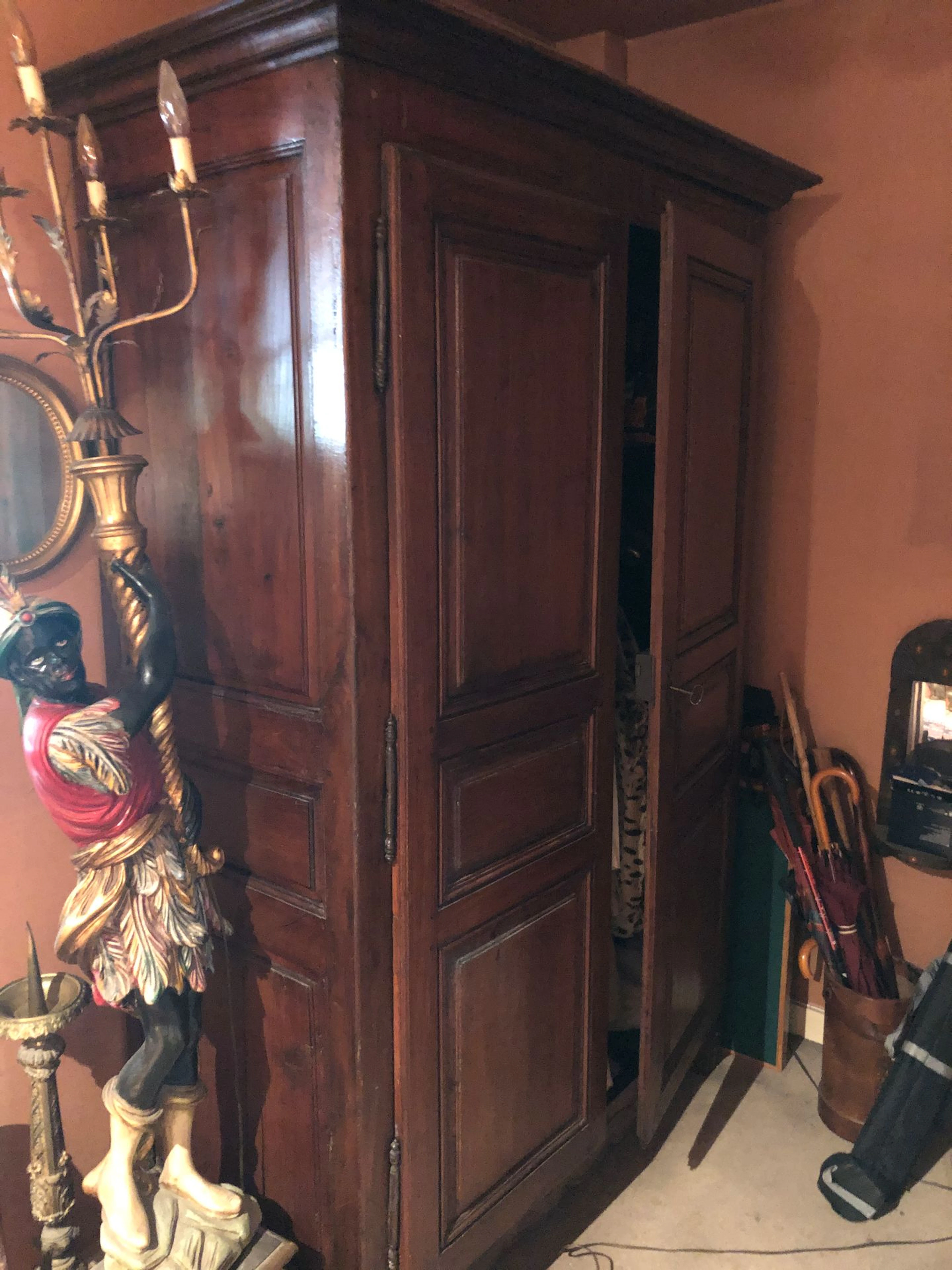 Armoire en bois foncé ouvrant par 2 portes..