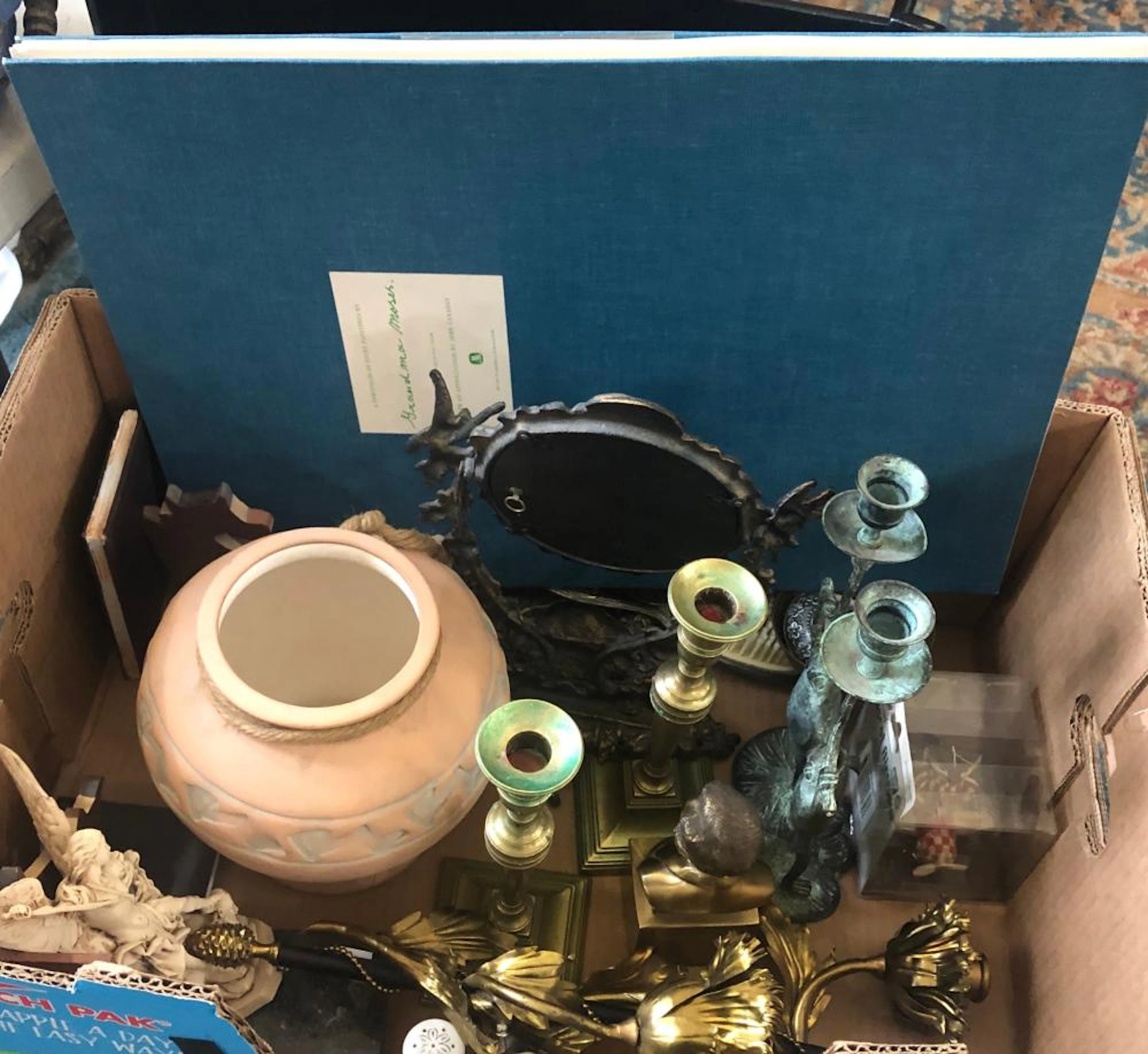 Pair of wooden bookends with cow design, a southwestern style vase, a composition statue of Saint Michael, salt and pepper shakers, a Victorian style metal vanity mirror, a pair of brass candlesticks,