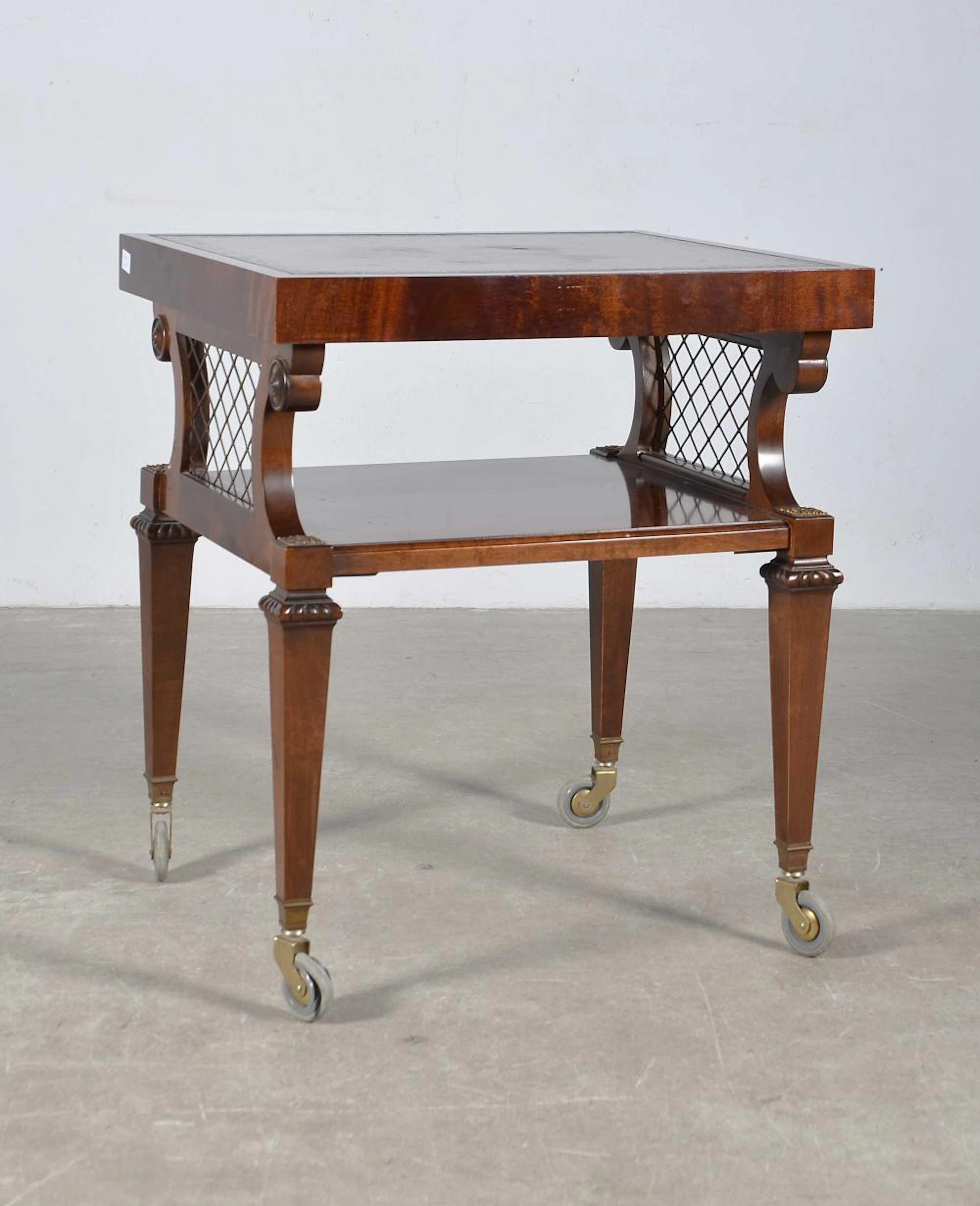 Mueble auxiliar sobre ruedas realizado en madera de Guinea con encimera de piel.