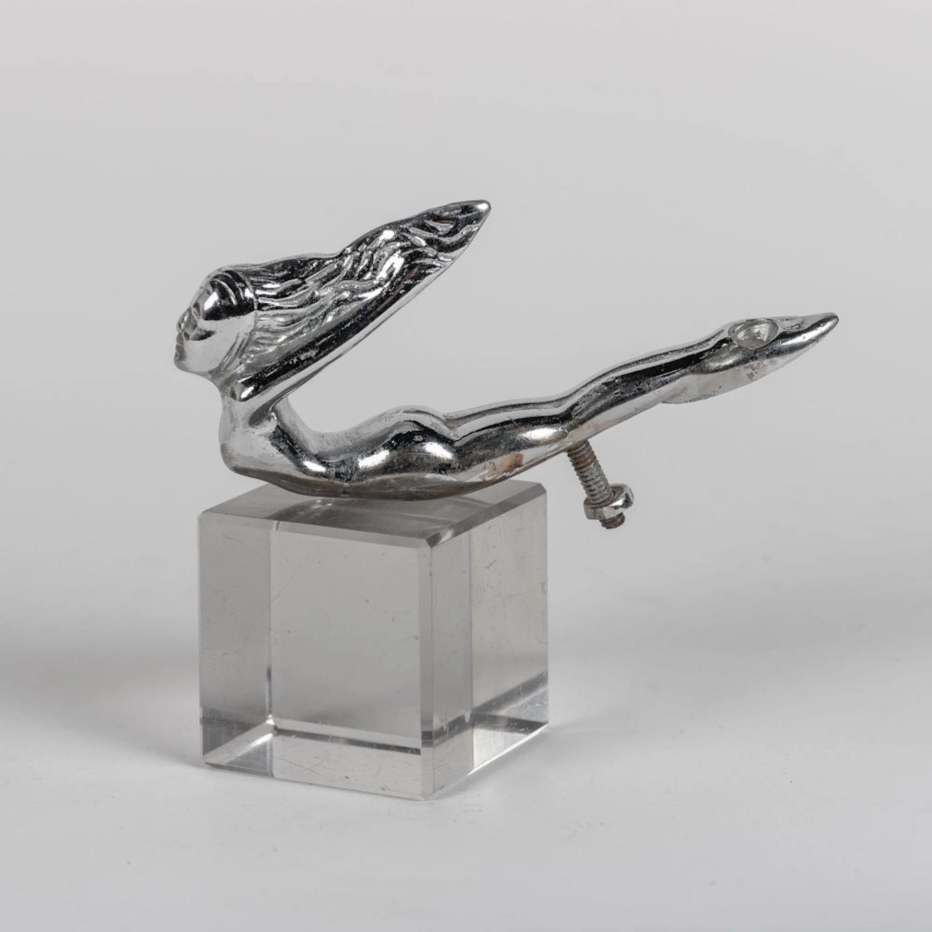 Insignia de coche antiguo realizado en metal plateado.