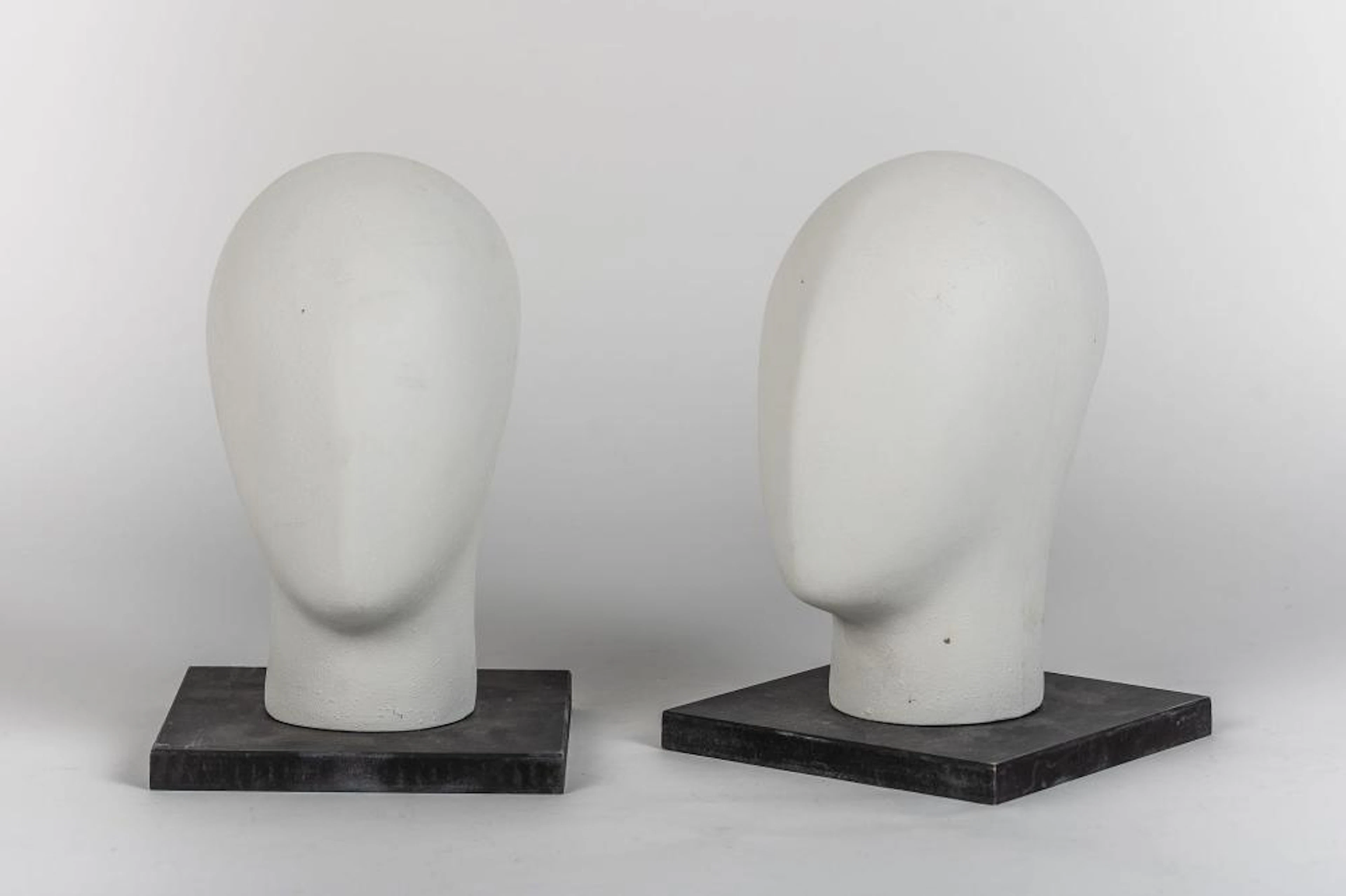 Pareja de cabezas modeladas realizadas en fibra de vidrio lacadas en blanco.