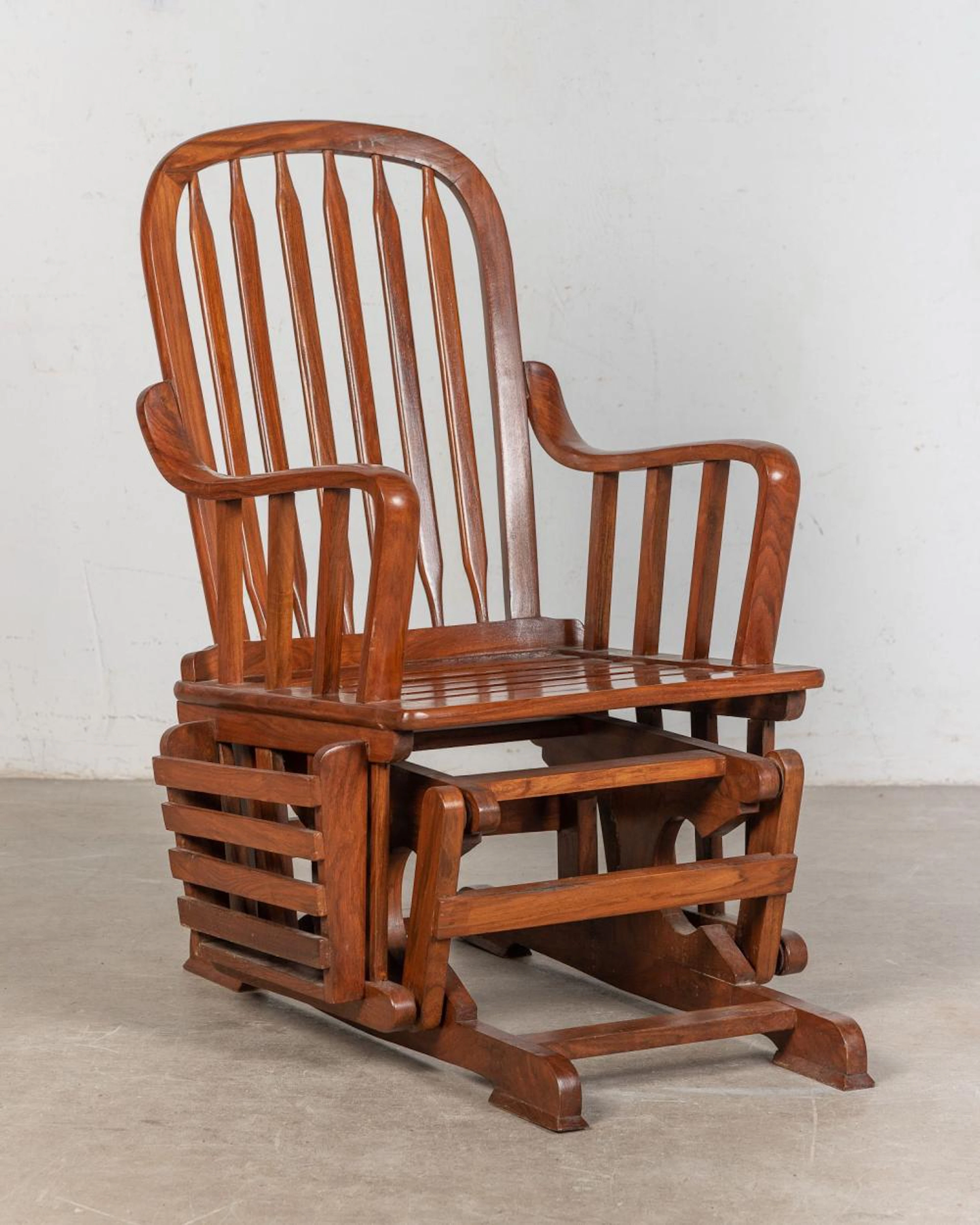 Butaca mecedora con revistero realizado en madera.