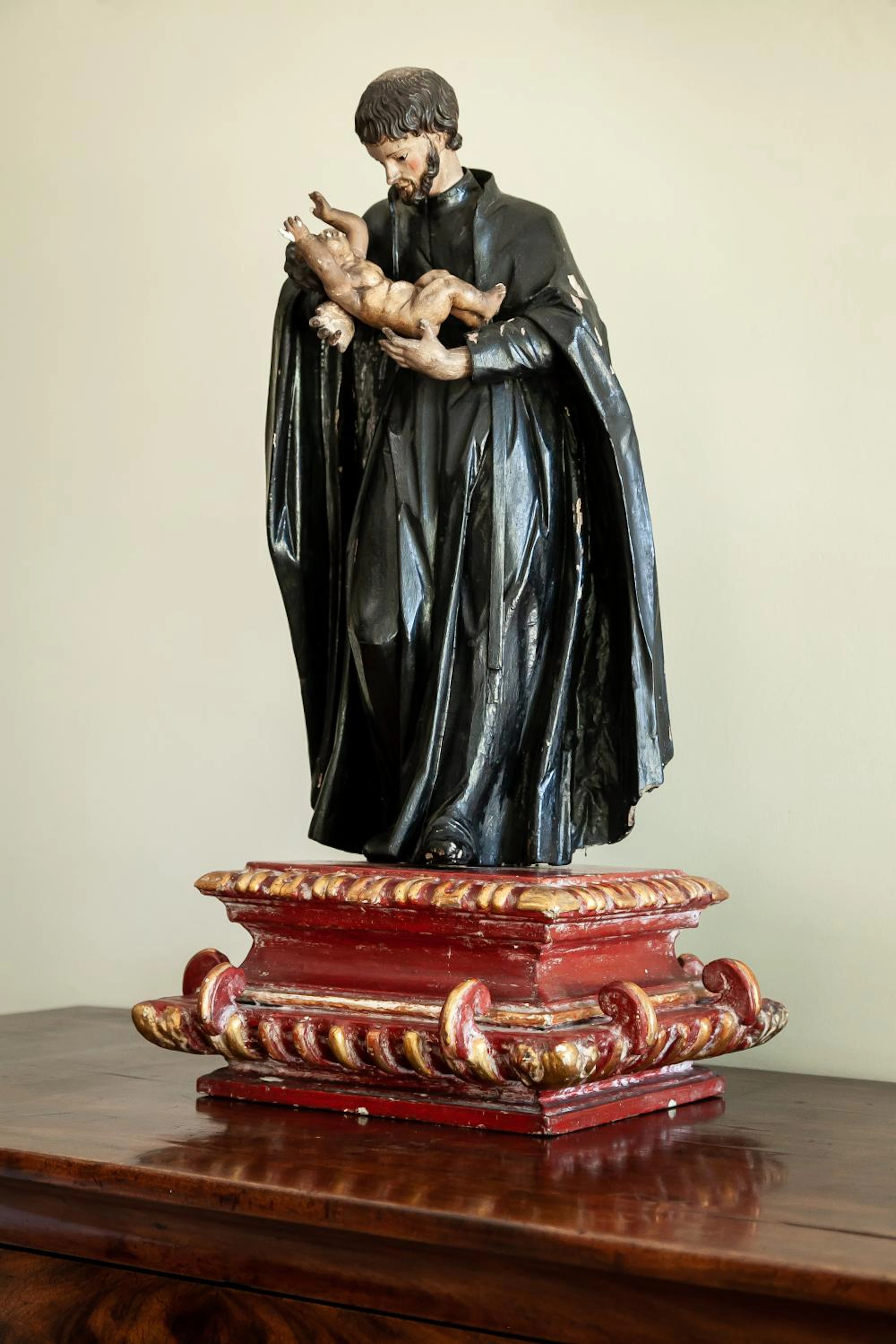 An 18th Century carved wood figure of a Jesuit Saint with Christ Child