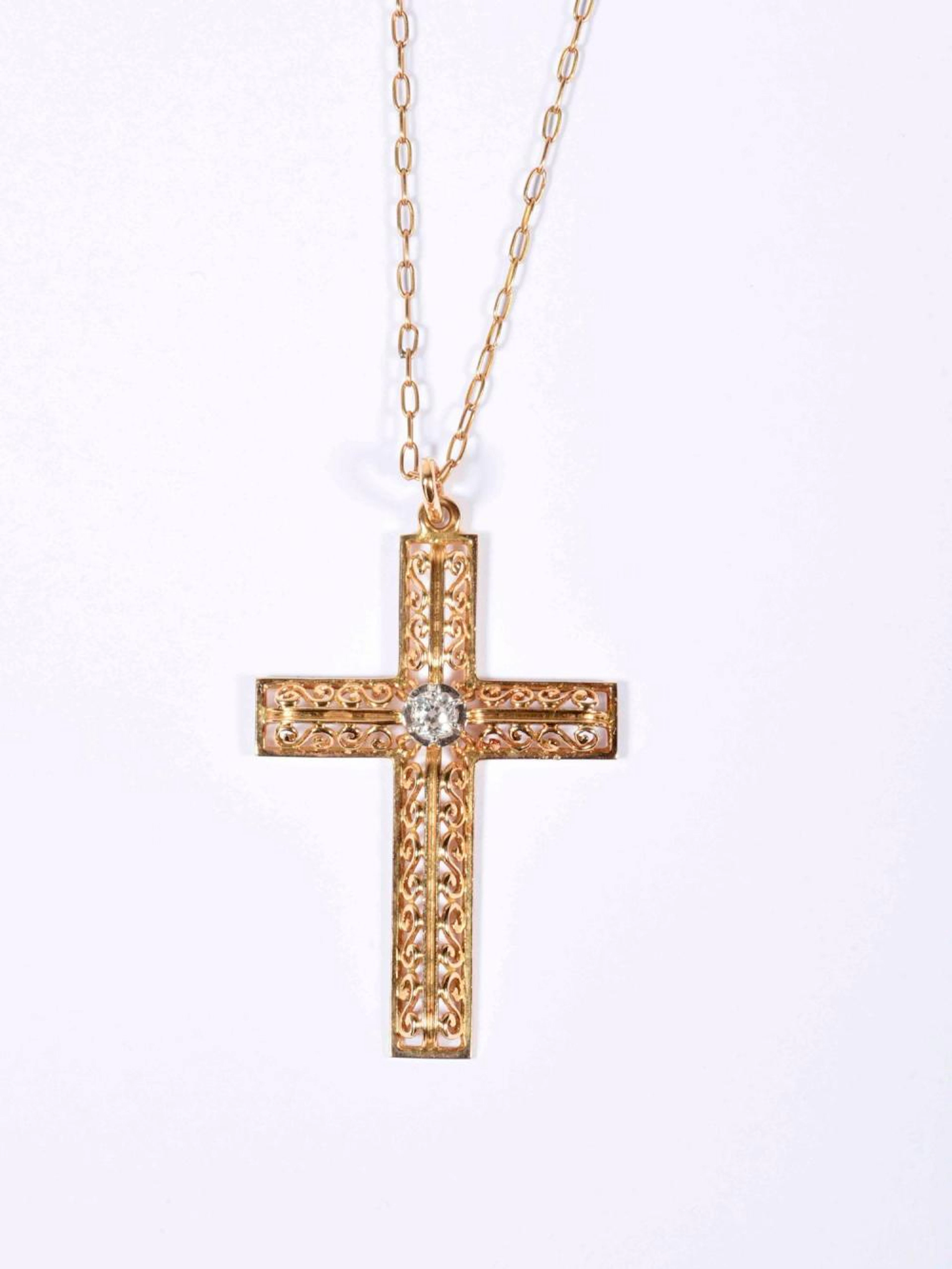 Pittoresque croix en or rose à décor d'entrelacs ajourés ornée d'un diamants