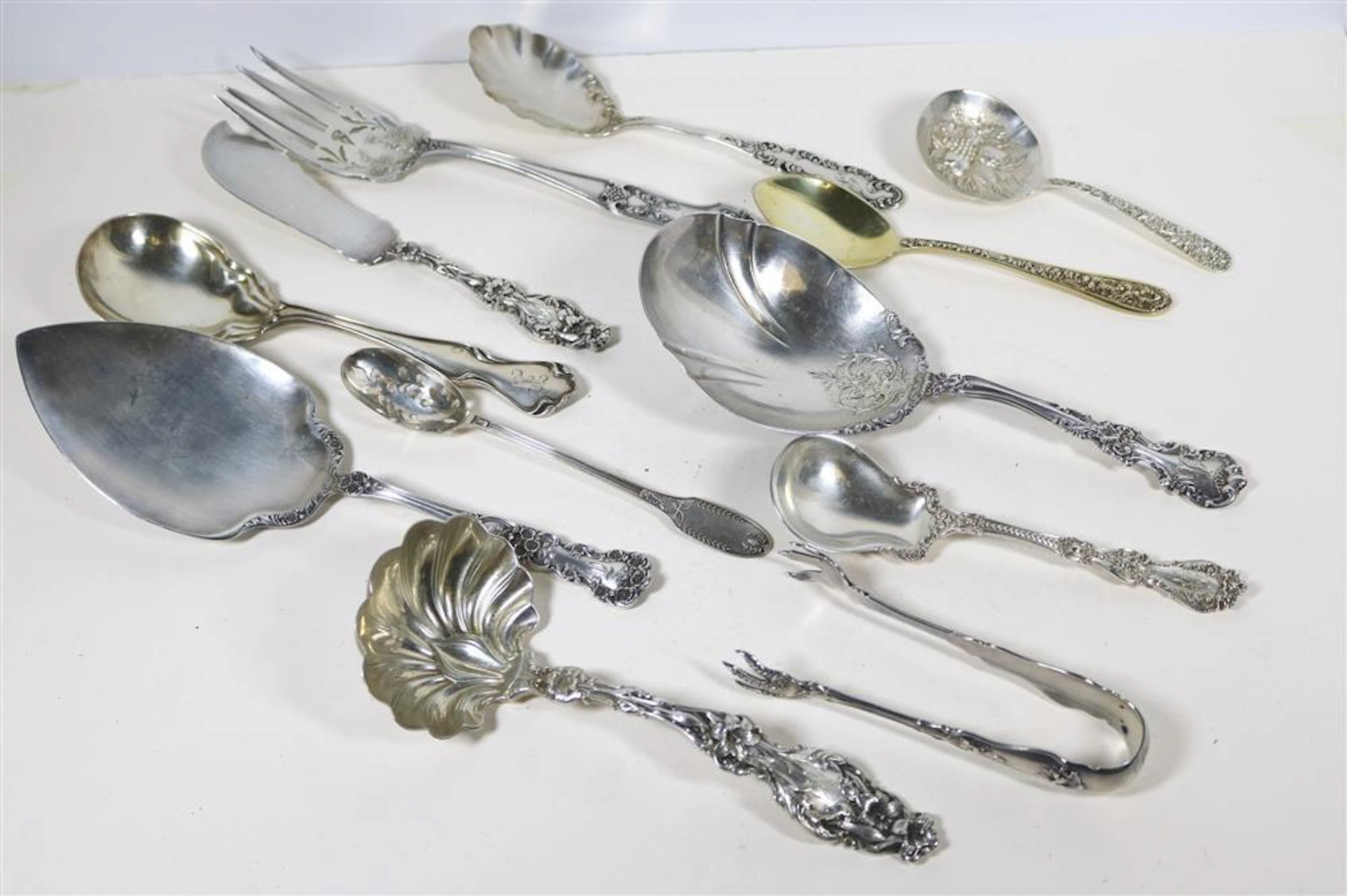 12 ASSORTED LATE 19TH-EARLY 20TH CENTURY STERLING SILVER SERVING UTENSILS.